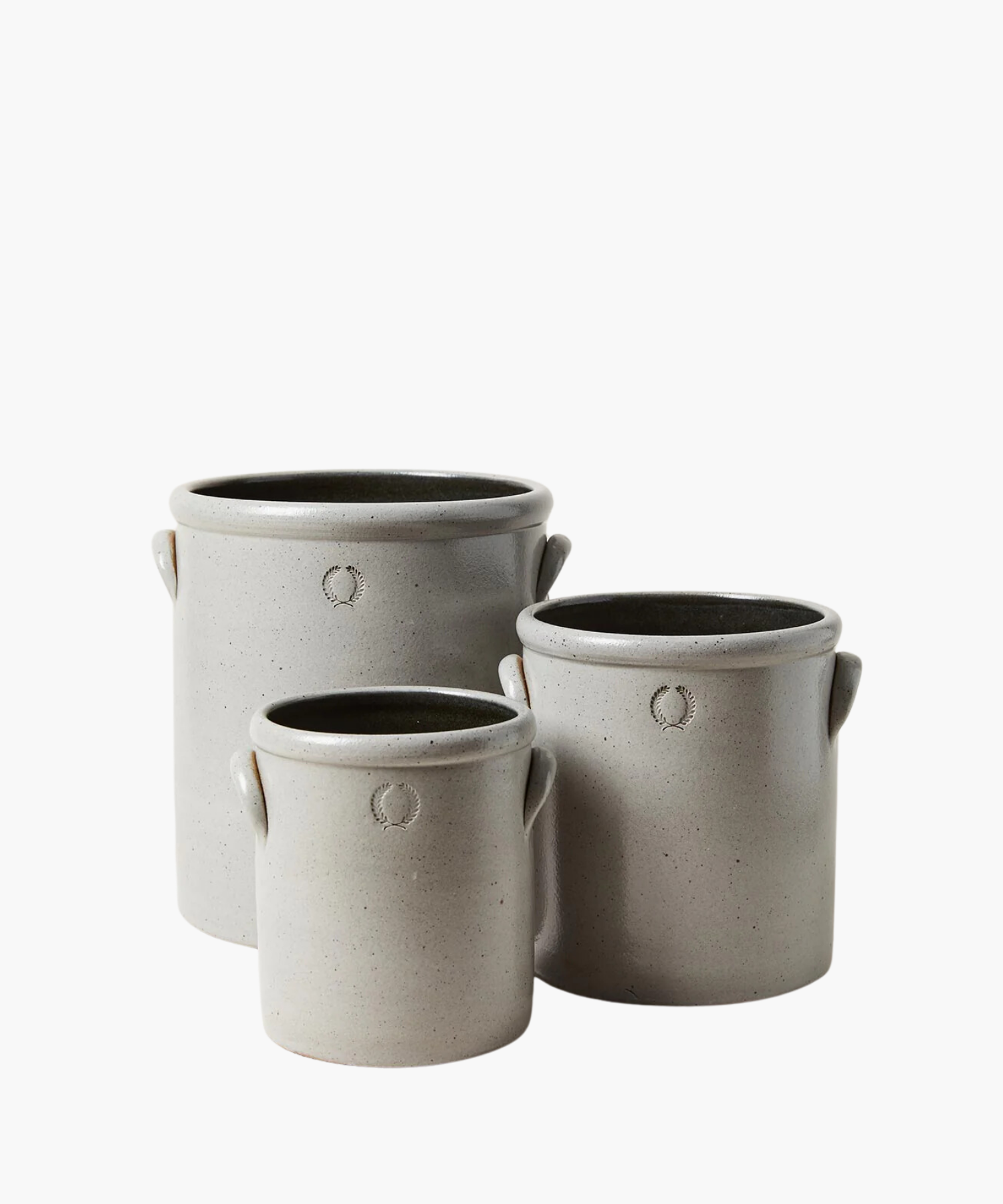 Three gray stoneware crocks of varying sizes with small handles. Each crock has a subtle embossed wreath design, conveying a rustic, artisanal feel. | Wildwood Home Co.
