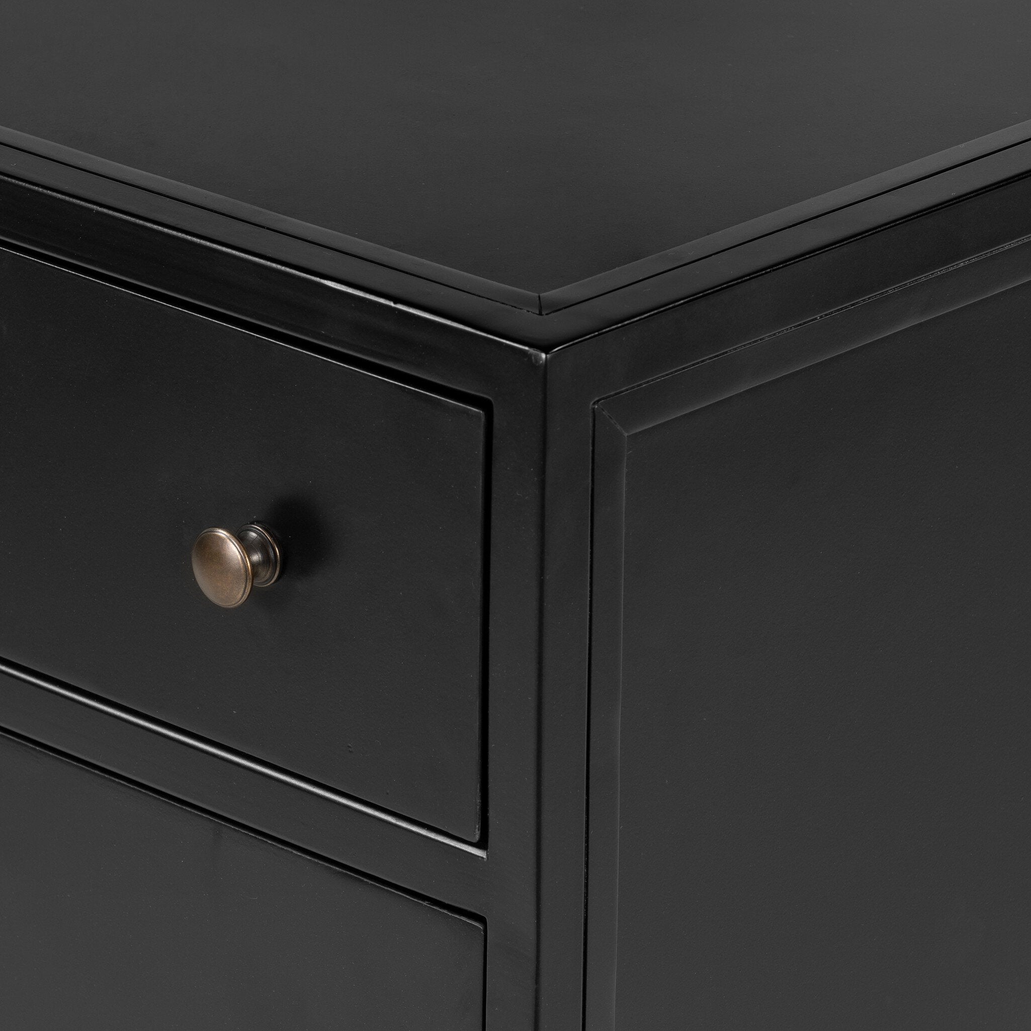 A black nightstand with three drawers and metallic knobs on a white background.