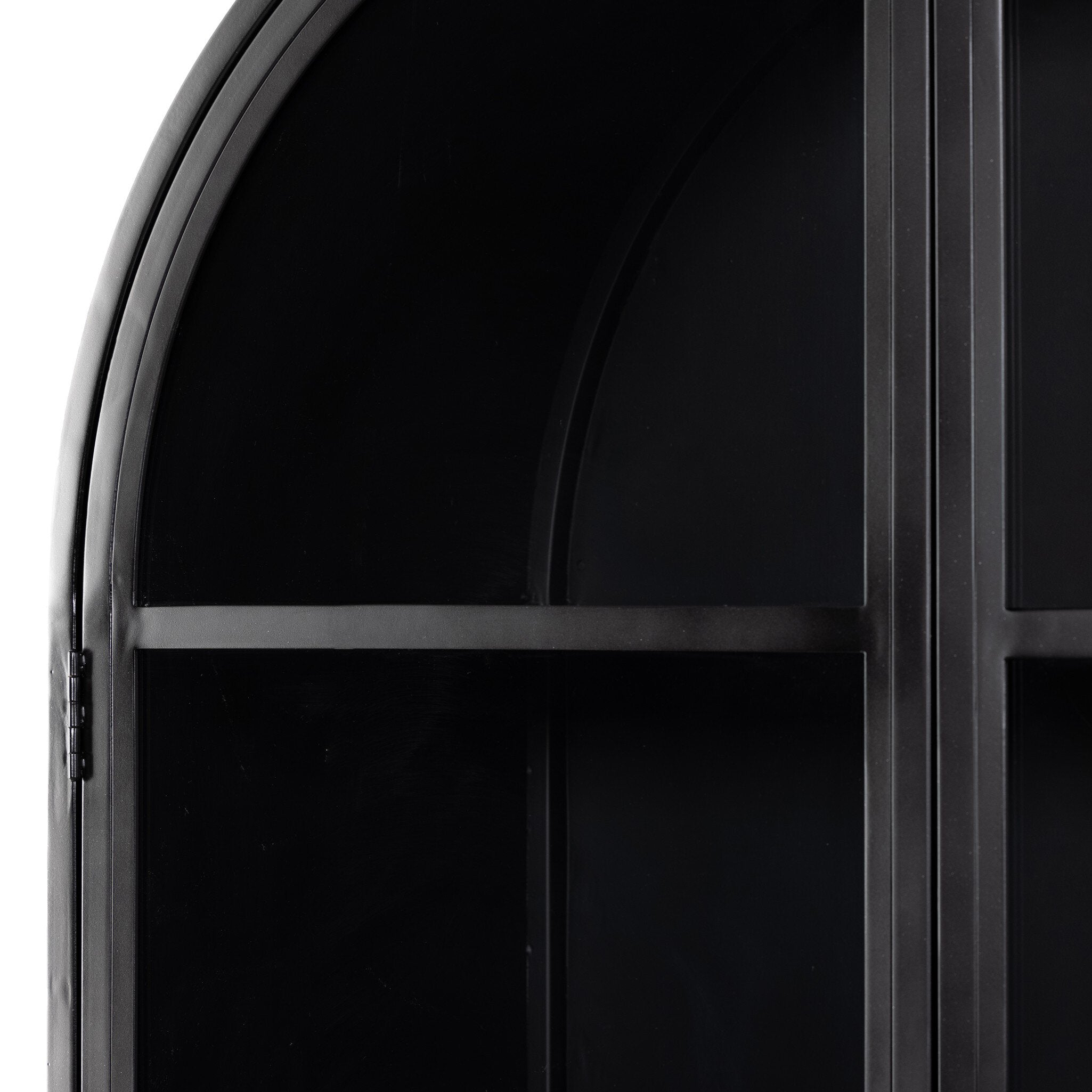 Close up of a black-finished iron arched cabinet with glass front doors. 