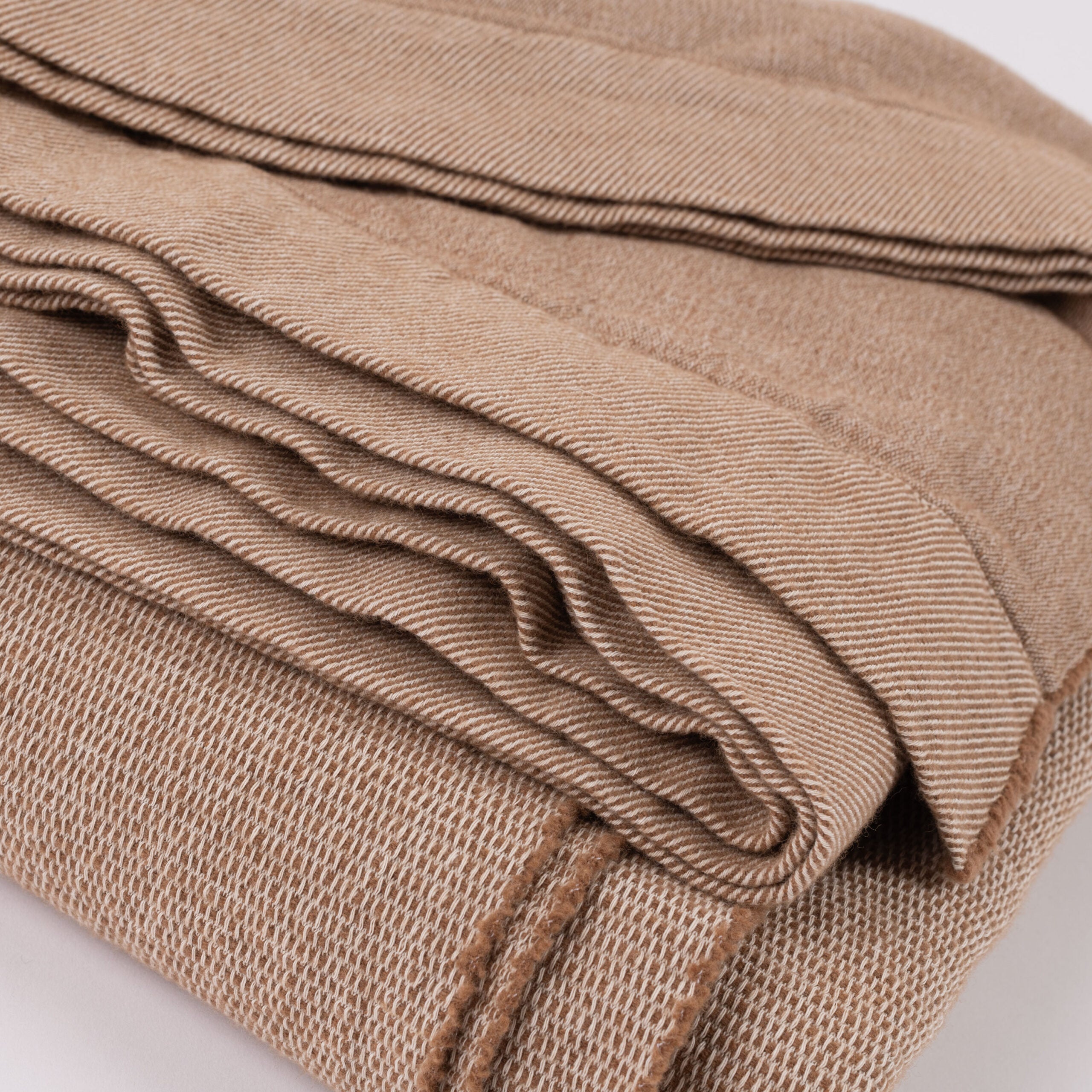 Close-up of Burhan Coverlet texture and edge detail, showing rich camel tone, soft knit weave, and neatly turned hem.