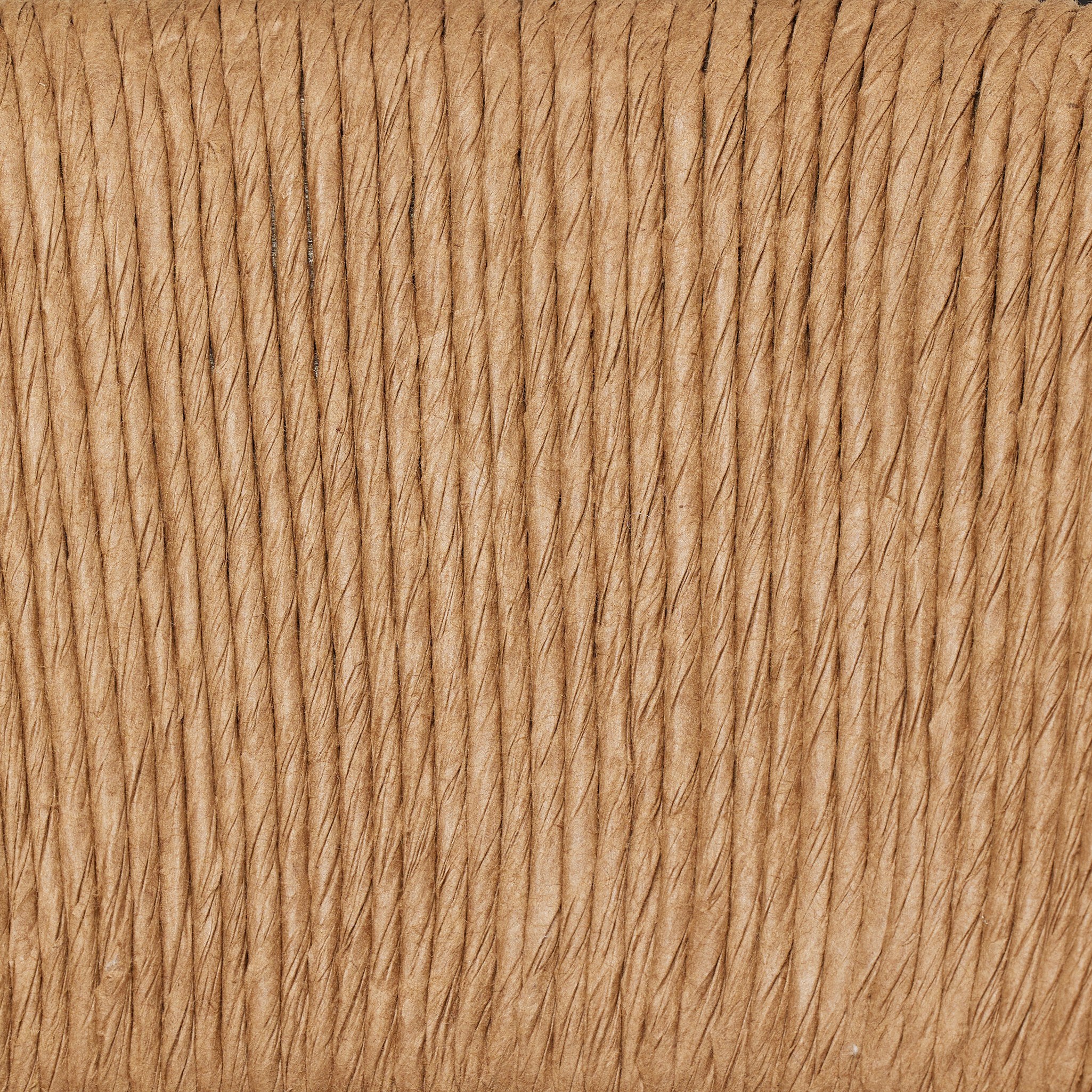 Close up of a solid oak dining chair with tapered legs and a woven backrest on a white background.