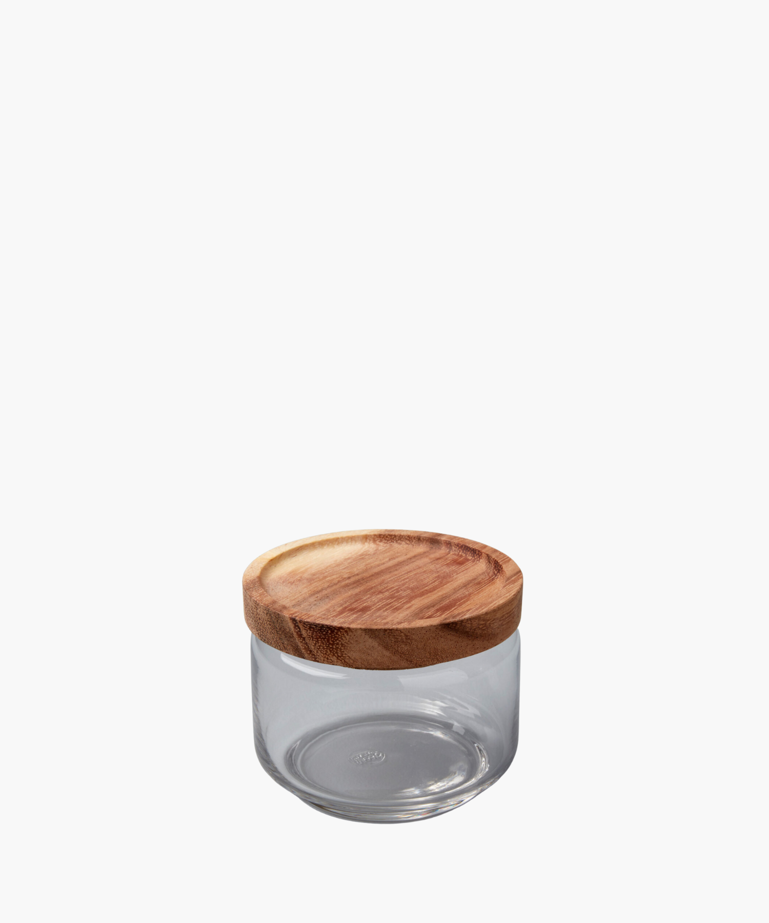 A clear glass jar with a round, smooth wooden lid sits against a white background. The simple, functional design conveys a minimalist aesthetic. | Wildwood Home Co.