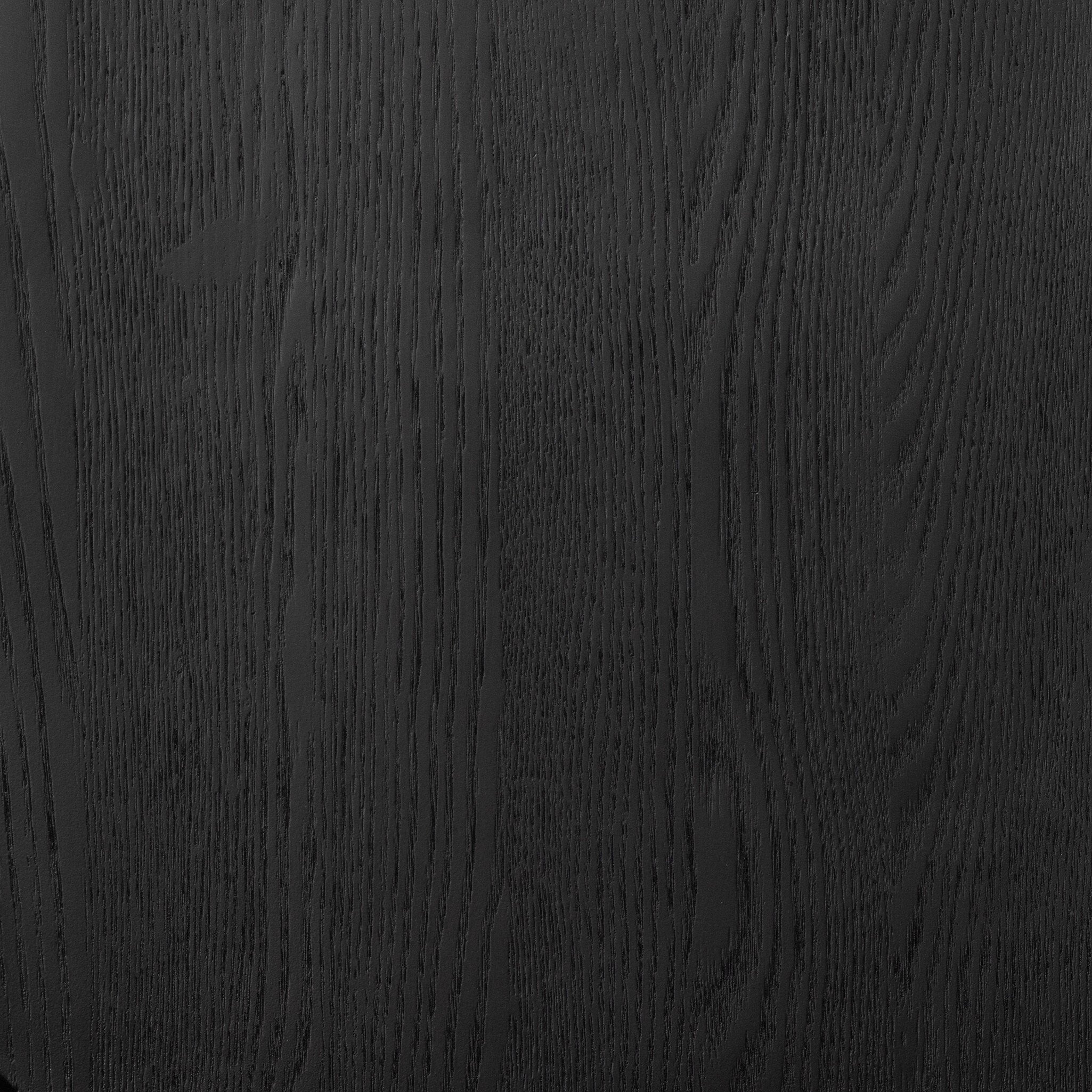 Close up of a black dining chair with a minimalist design on a white background.