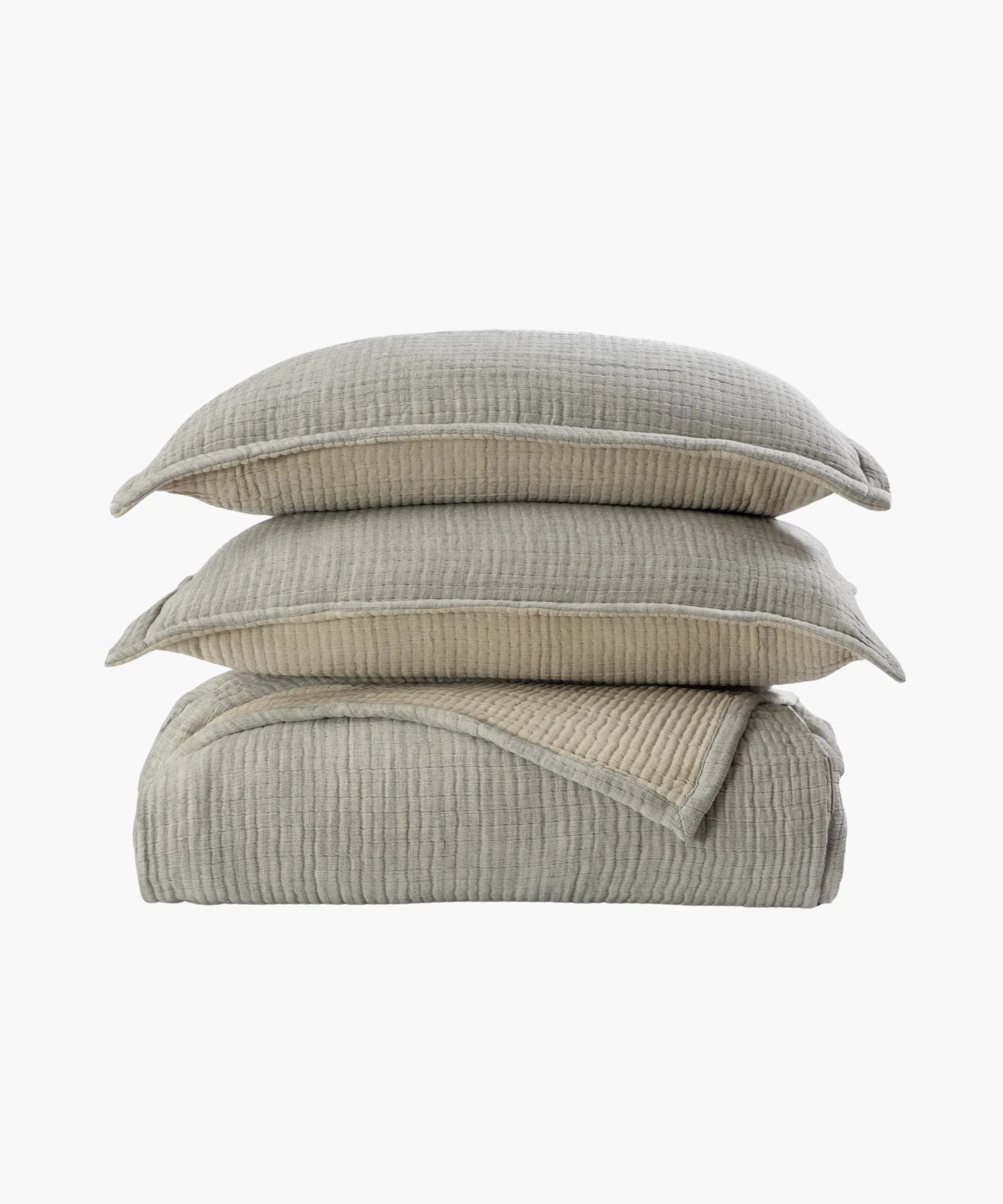 Folded textured blanket with two pillows on a white background
