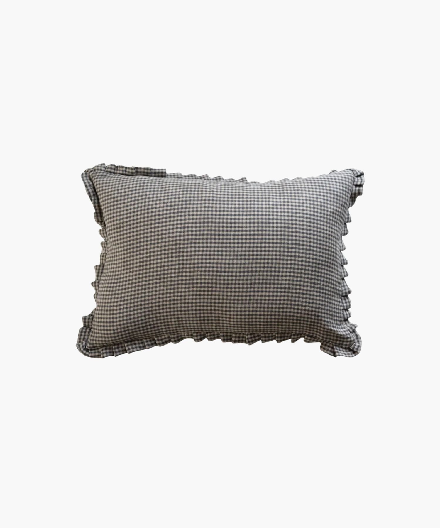 A rectangular lumbar pillow with a black and white gingham pattern and ruffled edges, conveying a classic and cozy feel, set against a plain background. | Wildwood Home Co.

