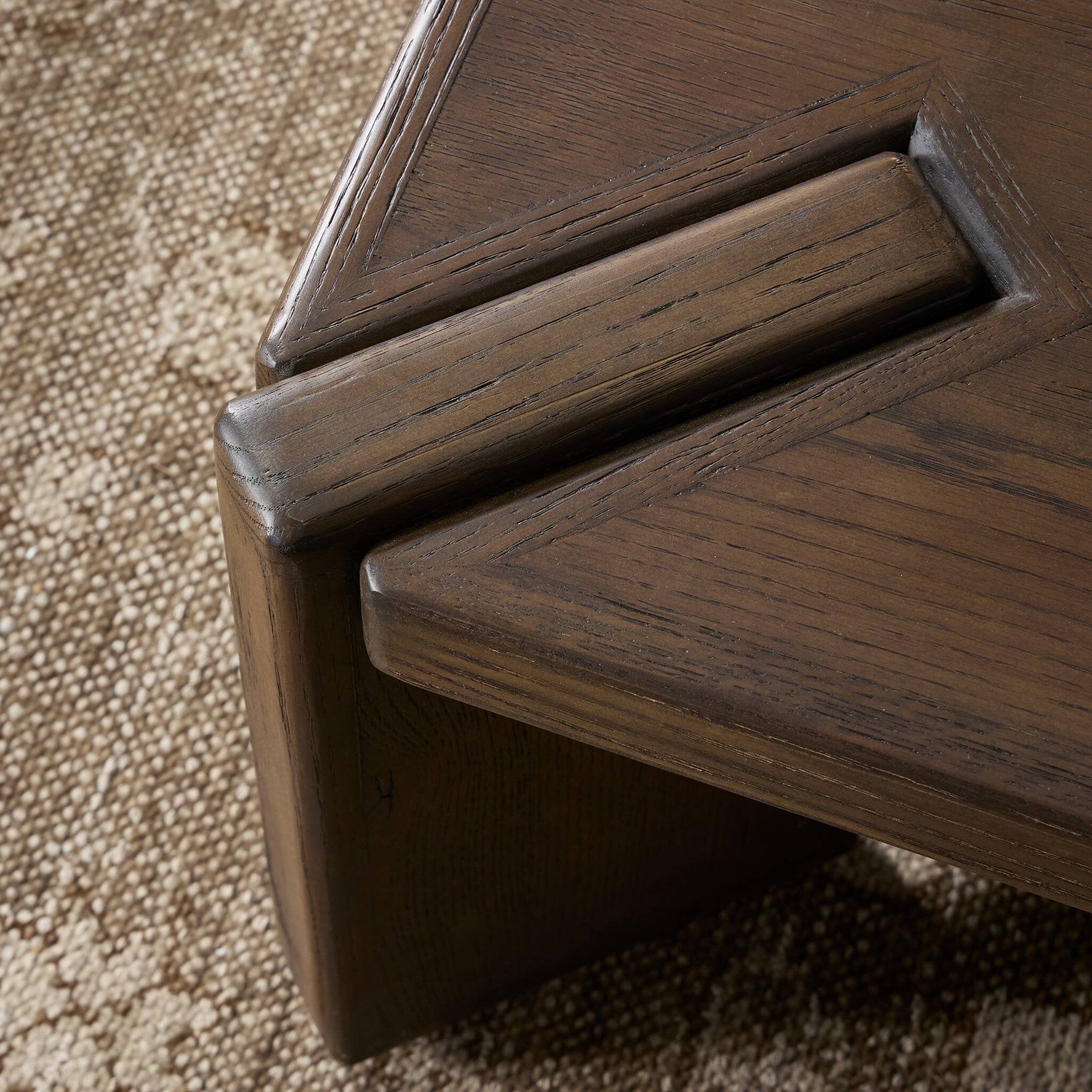 Close up of a wooden coffee table with a textured surface on a white background.