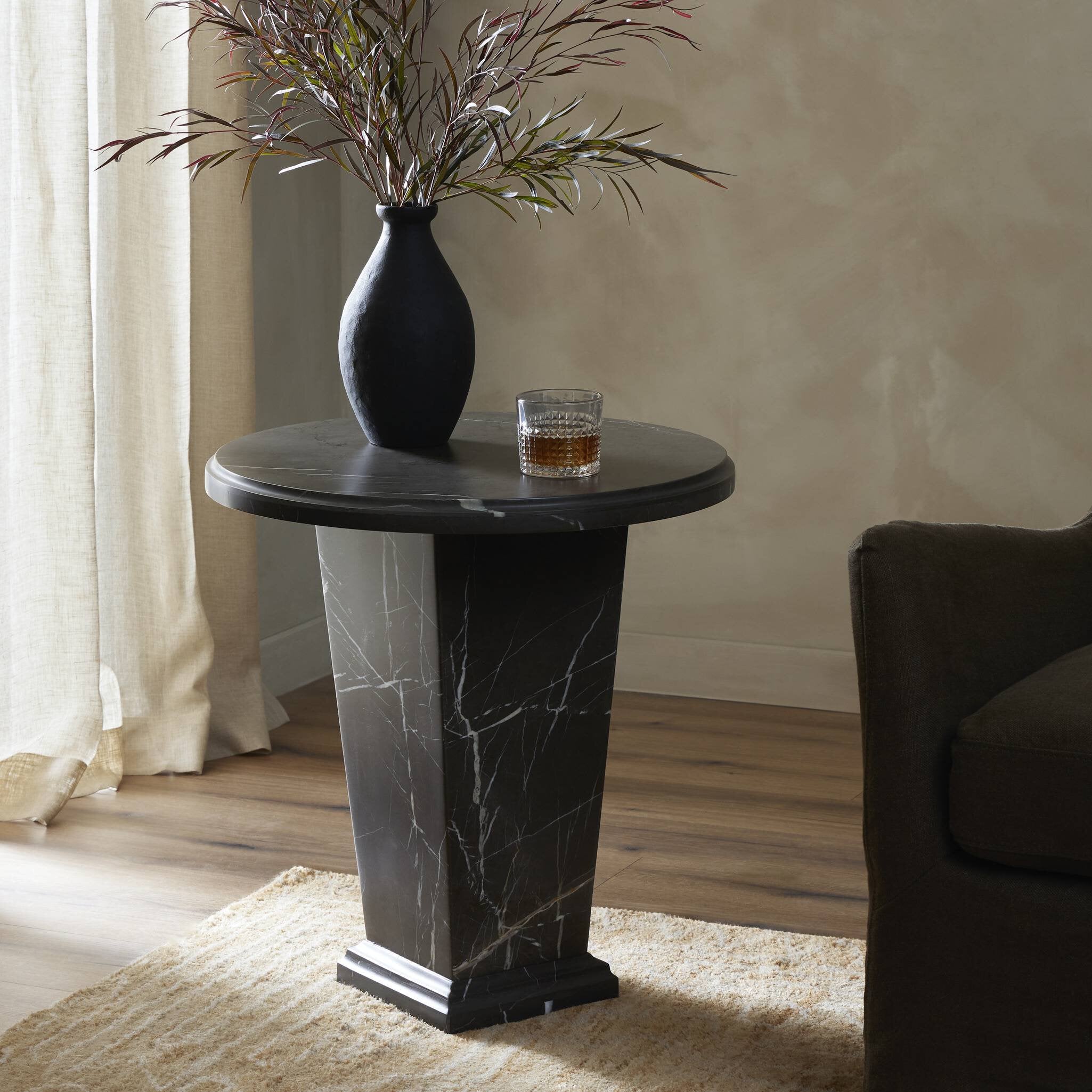 Round dark marble  end table with a vase and glass in a room setting. | Wildwood Home Co.