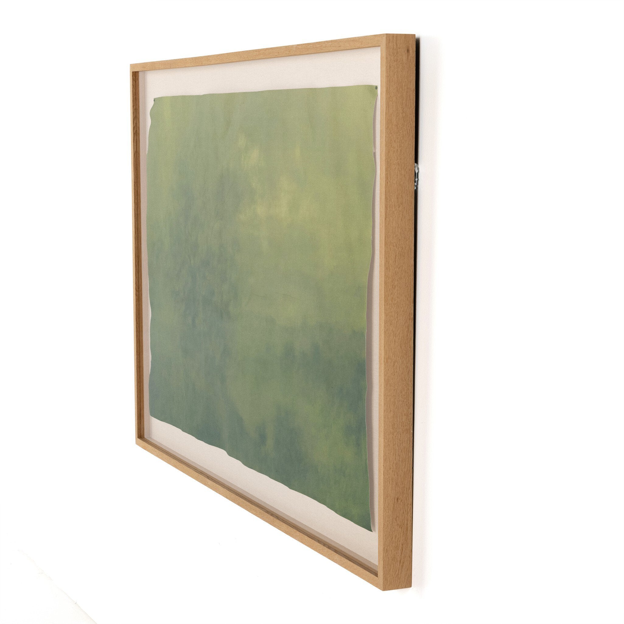 Framed artwork with a green abstract design on a white background.