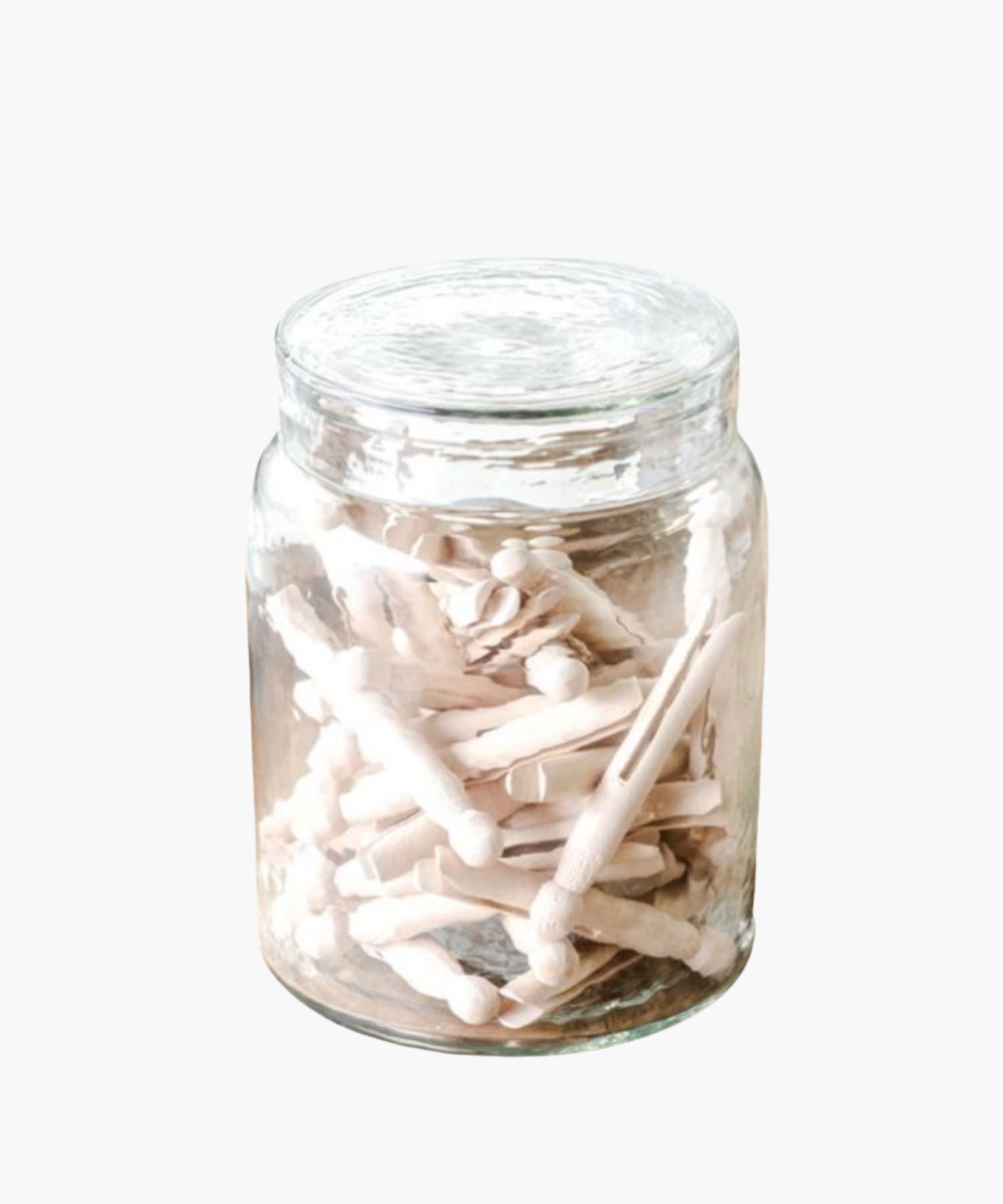 A clear glass jar filled with light-colored wooden clothespins against a white background. The scene conveys simplicity and vintage charm. | Wildwood Home Co.