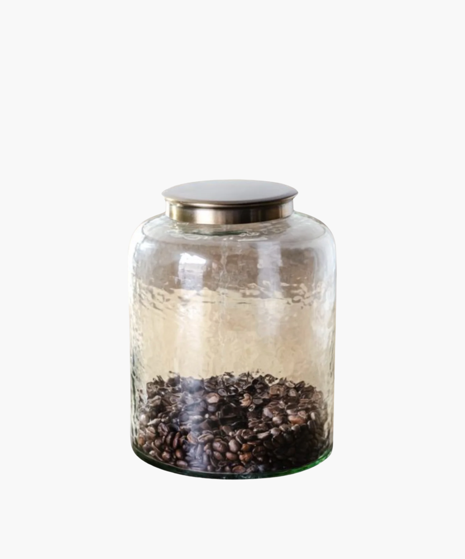 A transparent glass jar with a metallic lid, containing a layer of dark coffee beans at the bottom. The jar exudes a minimalist and rustic vibe. | Wildwood Home Co.