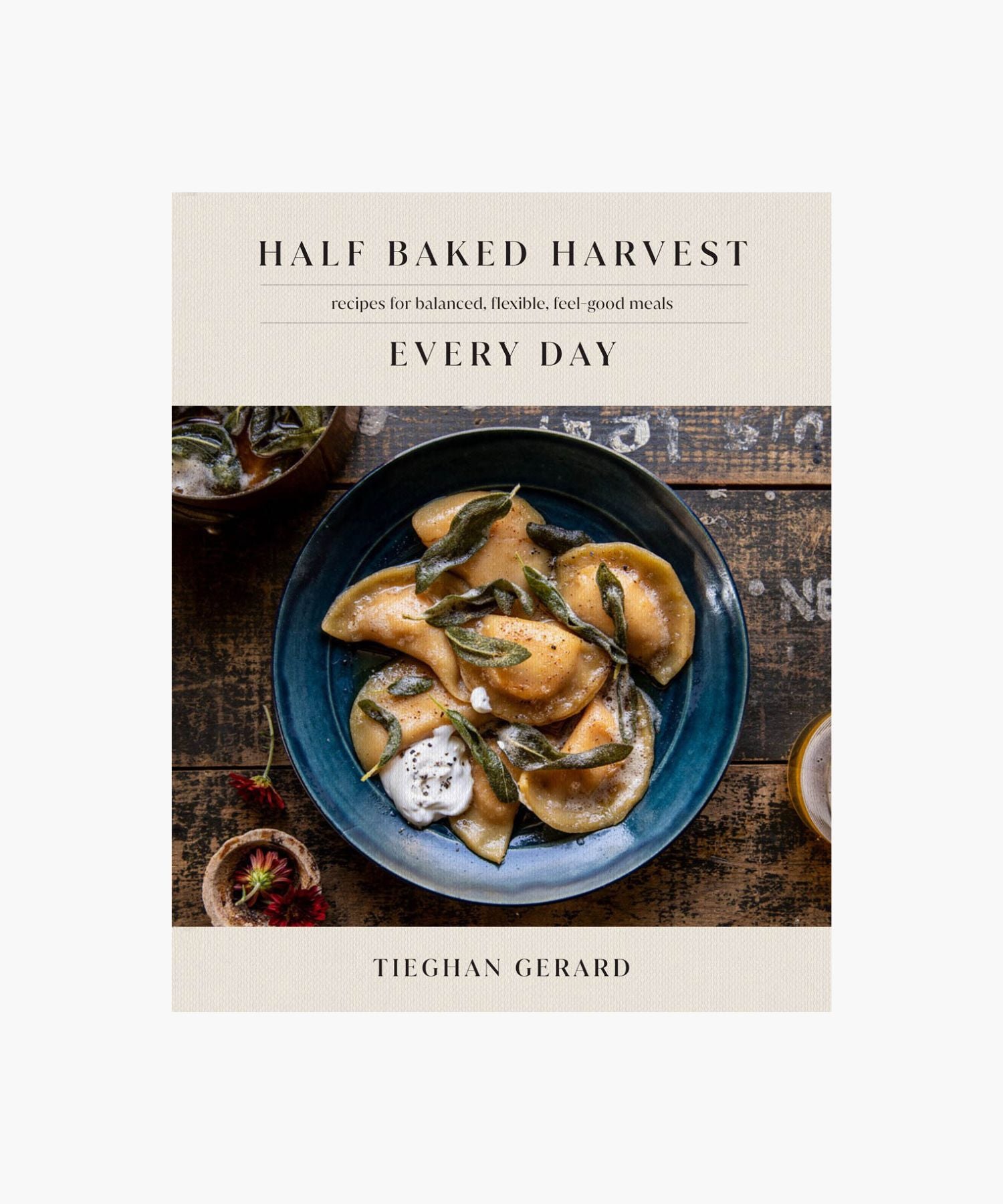 Cookbook cover titled "Half Baked Harvest Every Day" by Tieghan Gerard features a rustic, cozy image of ravioli with sage on a blue plate. | Wildwood Home Co.