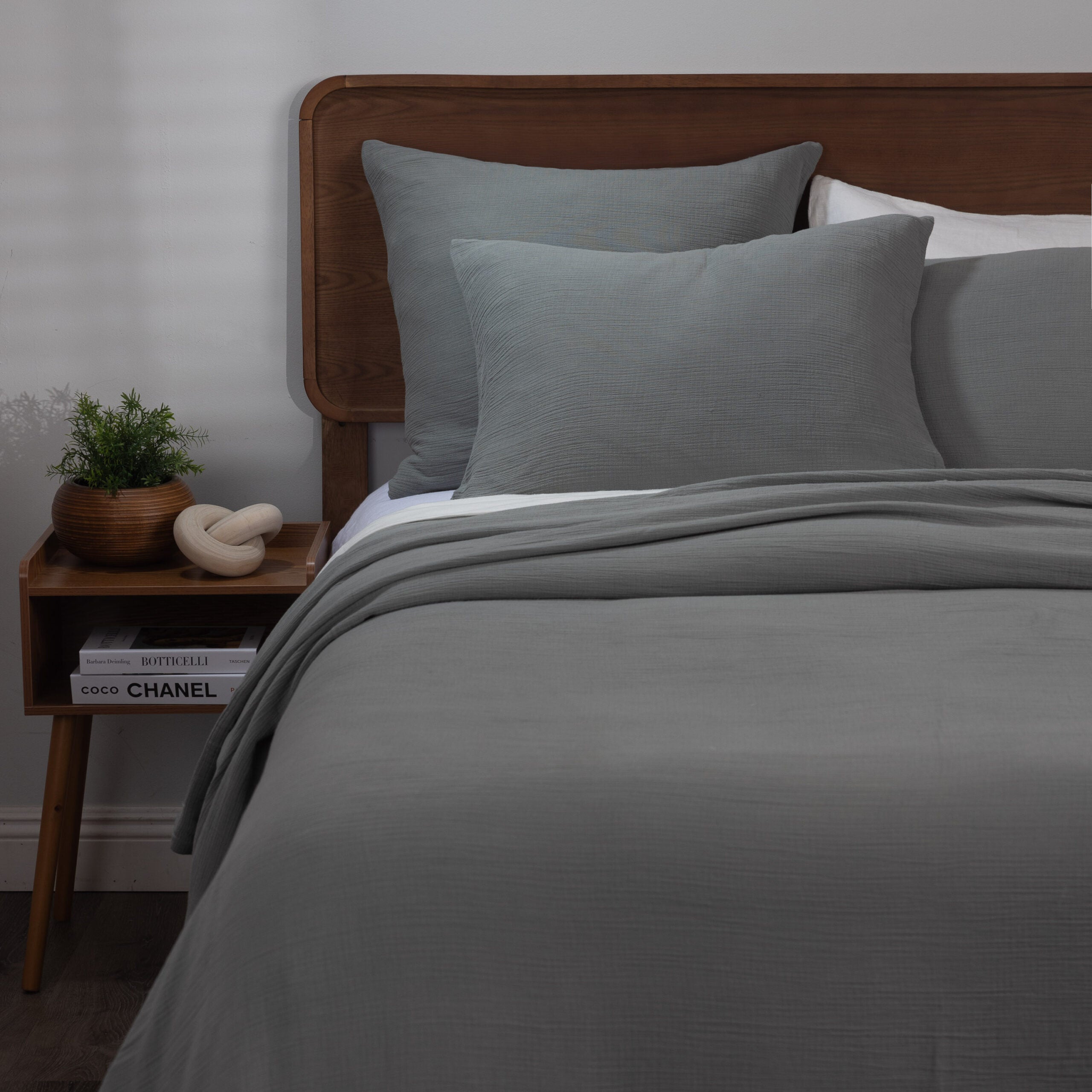 Bed styled with the soft gray Jenski duvet cover and shams with a subtle crinkle texture, paired with wood furniture for a grounded, modern look. | Wildwood Home Co.