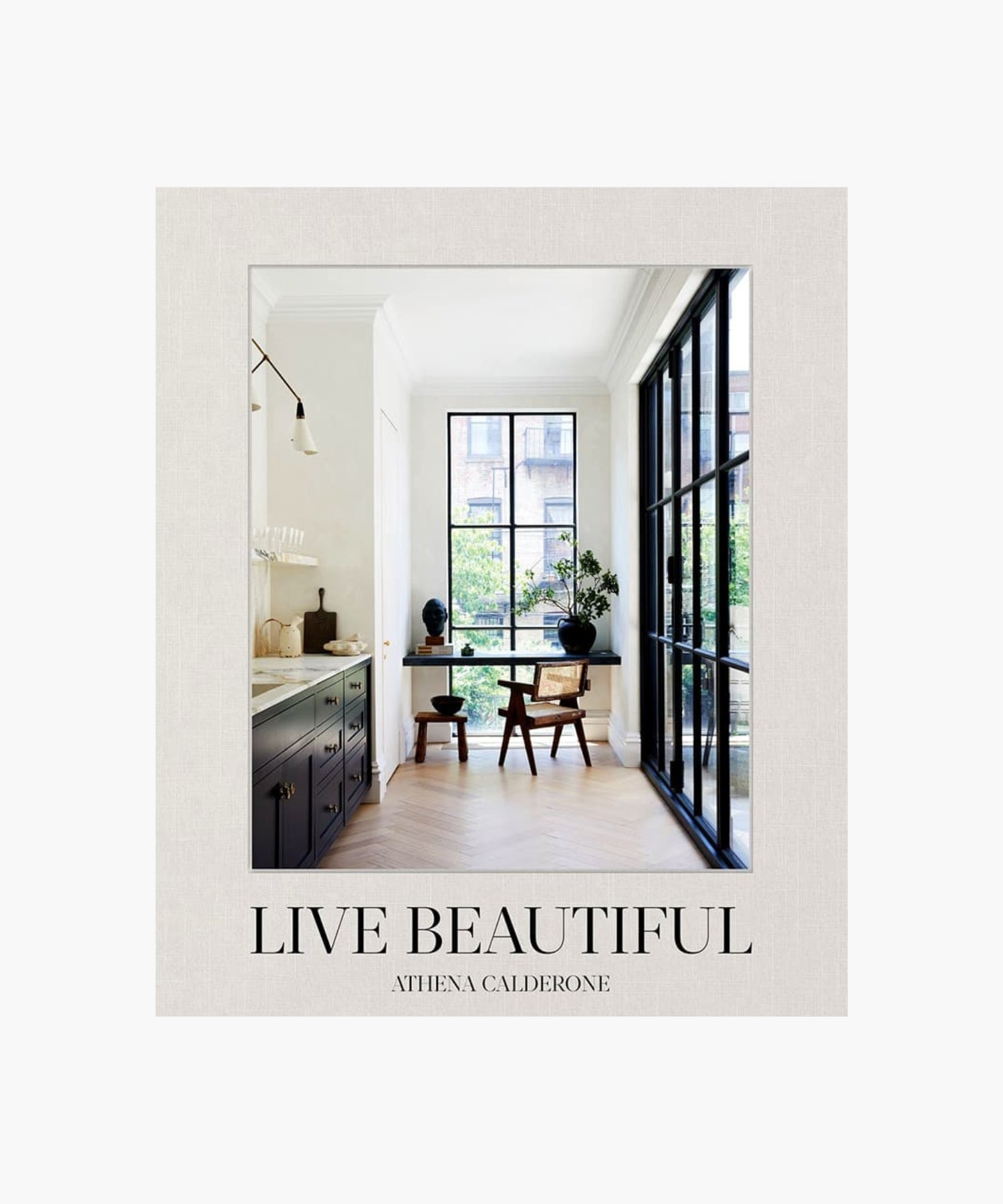 The cover of the book "Live Beautiful" by Athena Calderone features a stylish interior design with large windows, minimalistic furniture, and natural light. The tone is serene and elegant. | Wildwood Home Co.
