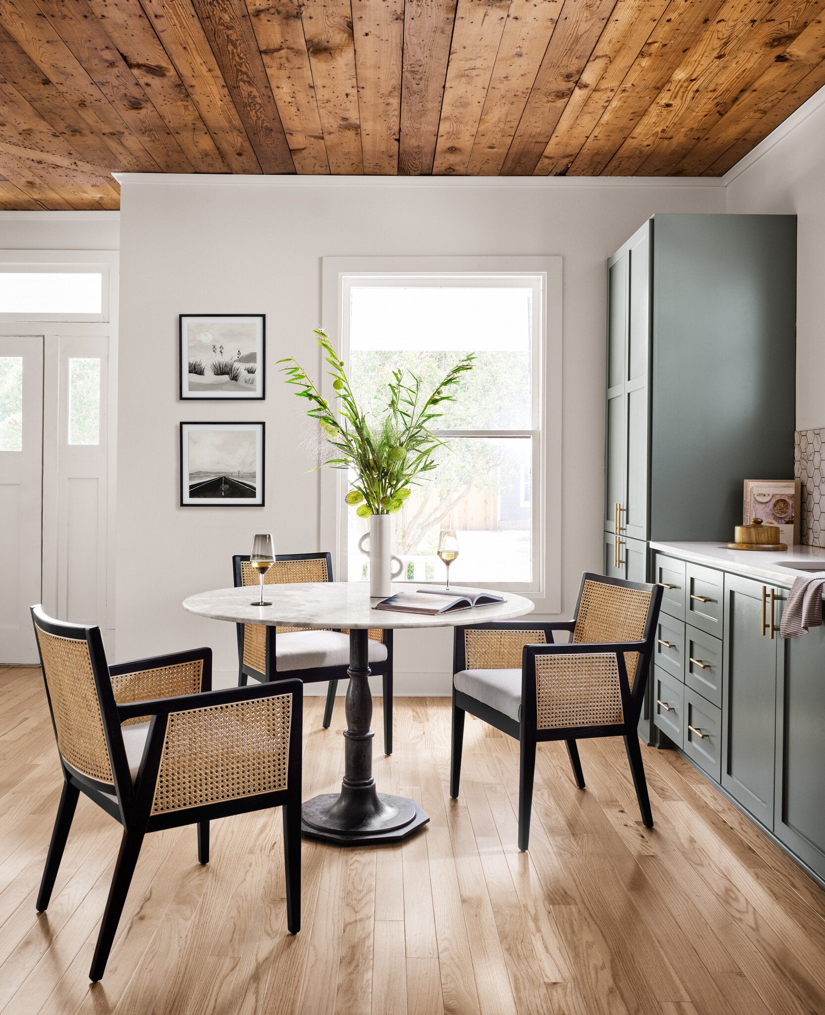 Round marble dining table with a black metal pedestal base on a white background. | Wildwood Home Co.