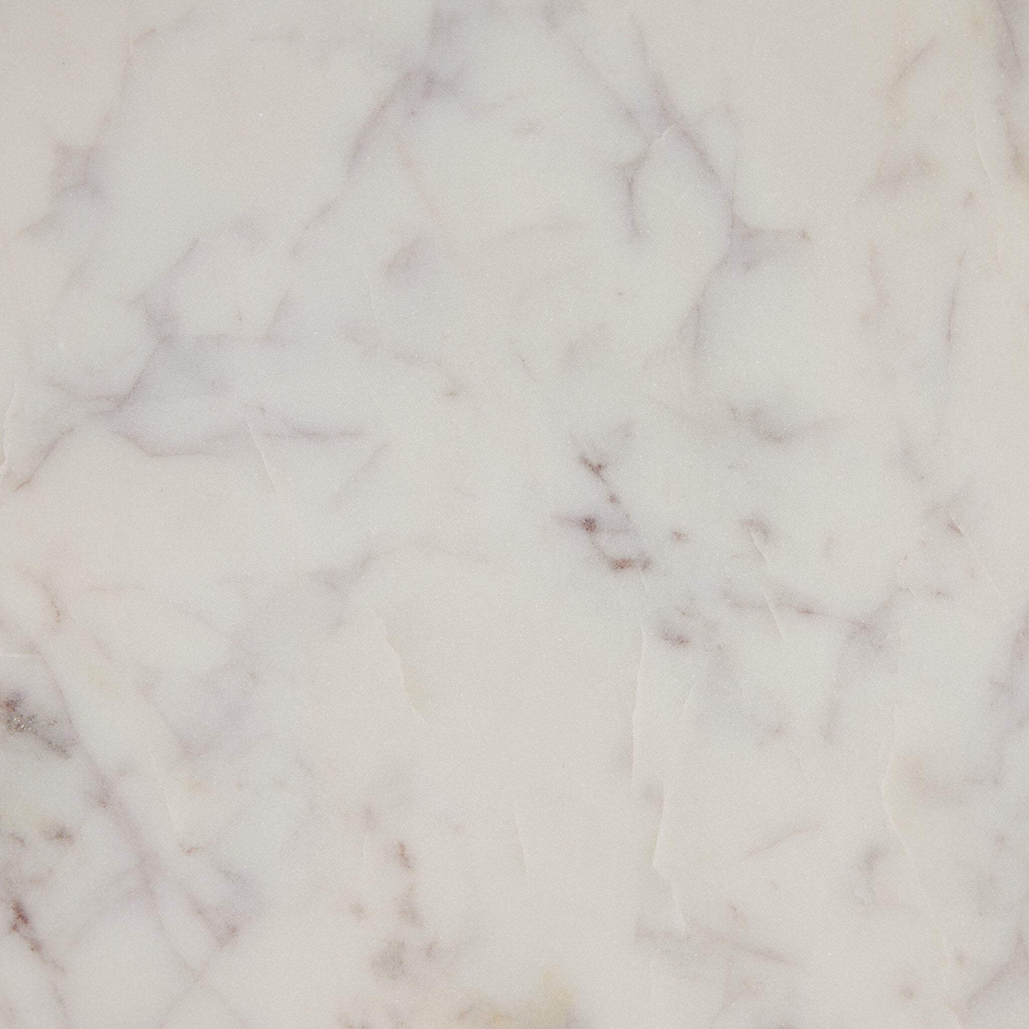 Close-up picture of one of the table tops showing white marble surface with gray and white veining. 