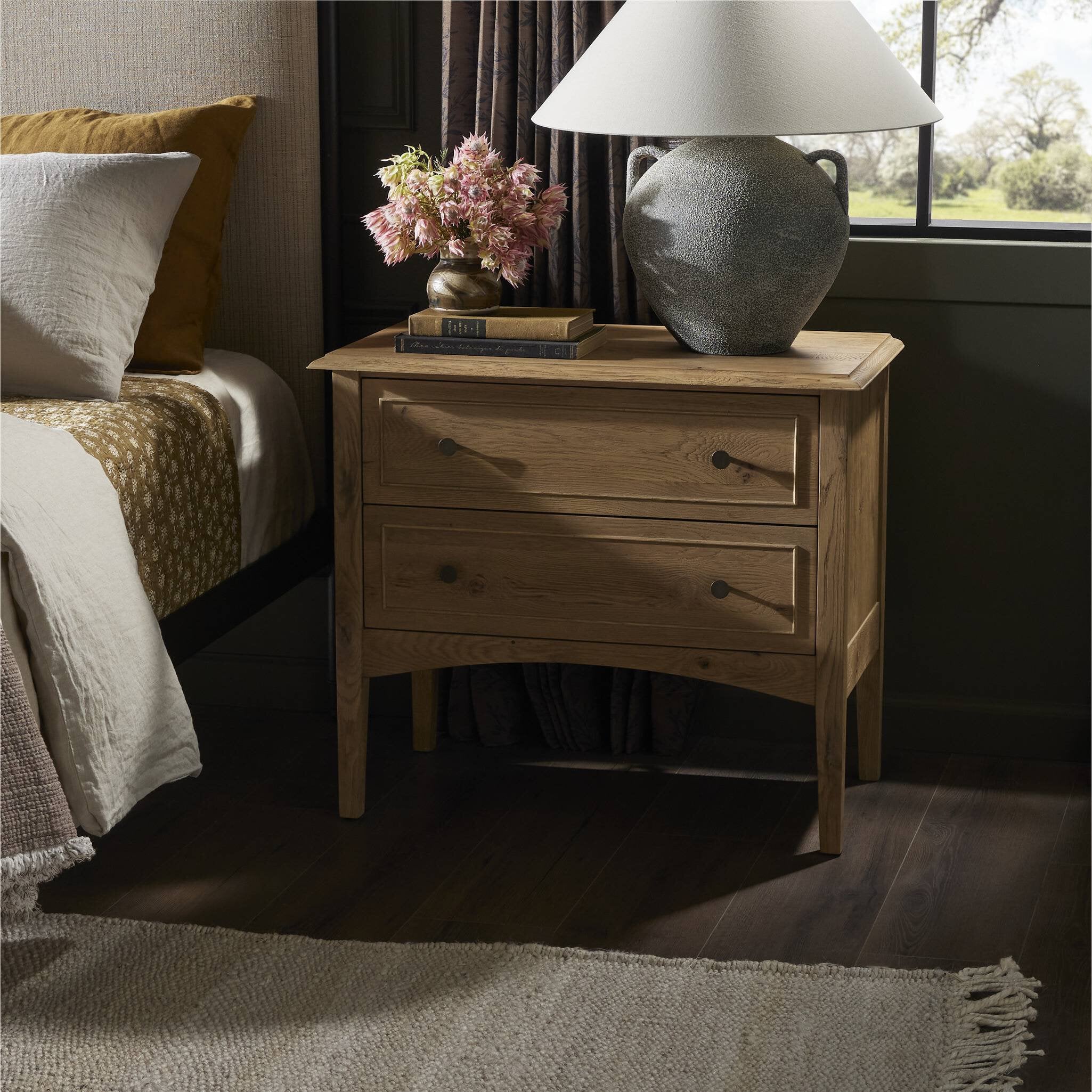 Wooden nightstand with two drawers styled in a bedroom with a lamp and books.  | Wildwood Home Co.