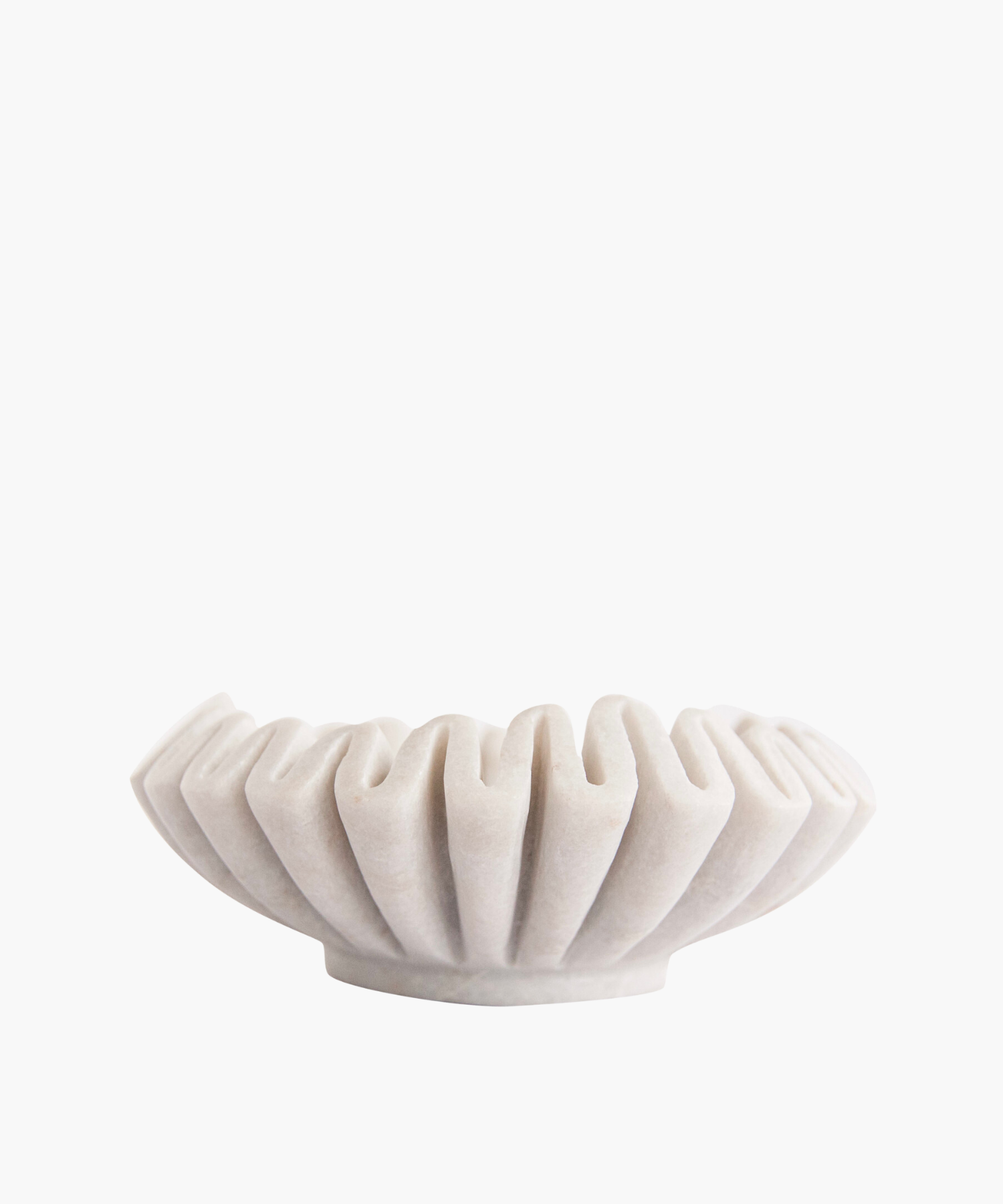 Elegant white marble bowl with a pleated, fan-like design. Its sculptural form and soft shadows create a minimalist and artistic appeal. | Wildwood Home Co.