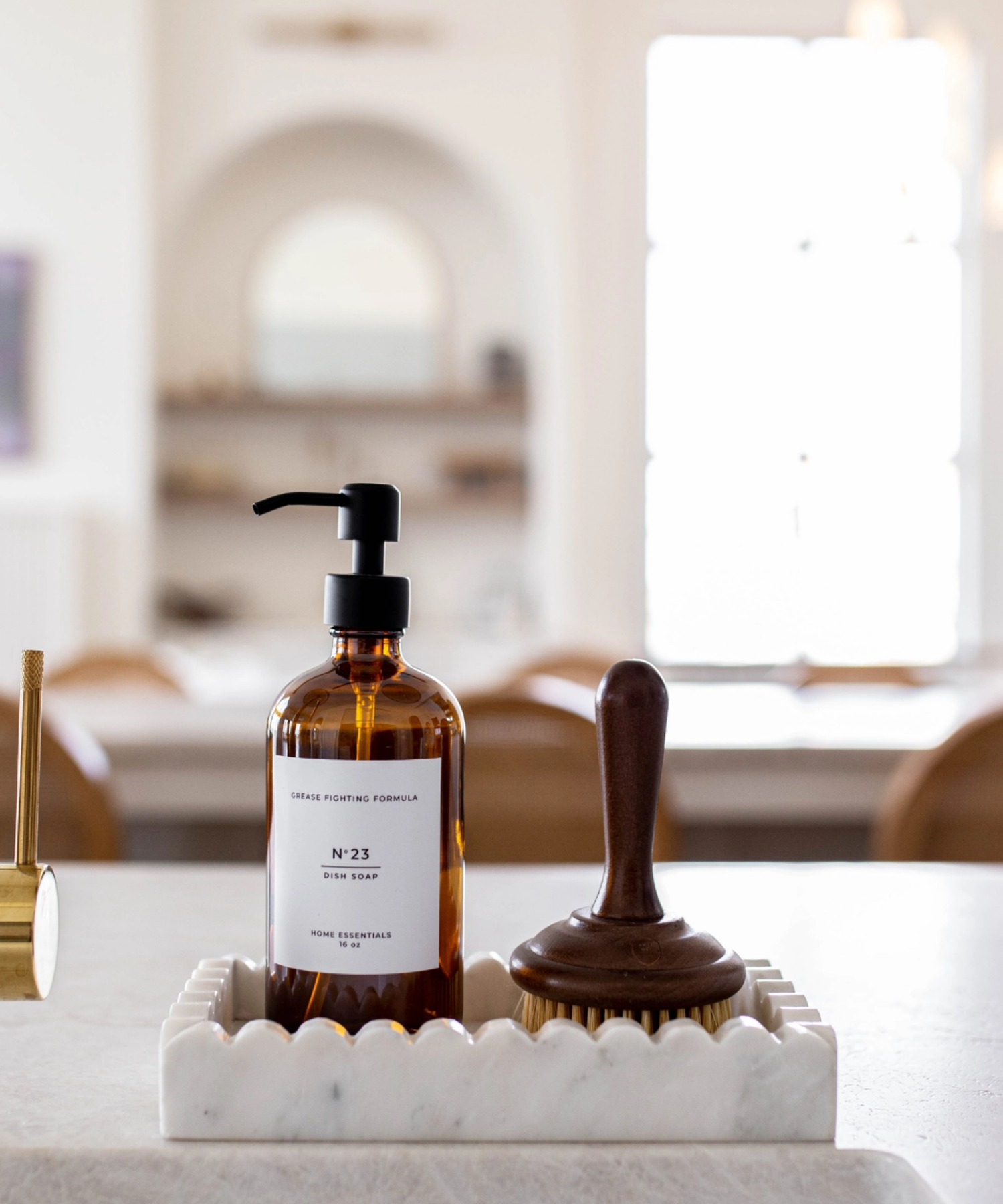 Rectangular marble tray with a scalloped border styled with soap and saucepan brush. The polished surface has a smooth texture, giving it an elegant and minimalist appearance.