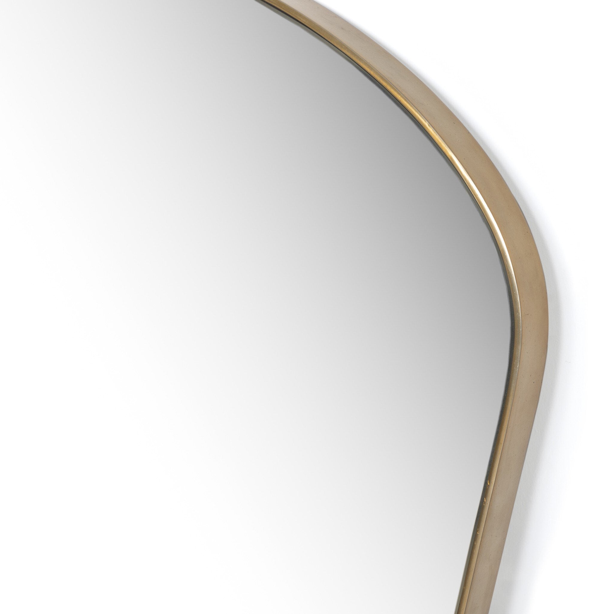 Close up of a decorative wall mirror with a gold frame on a white background. | Wildwood Home Co.