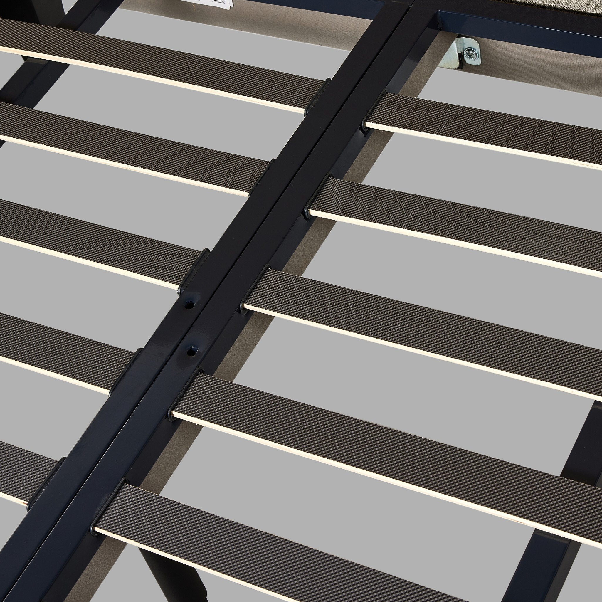 Close up of a beige upholstered bed with white bedding on a white background.