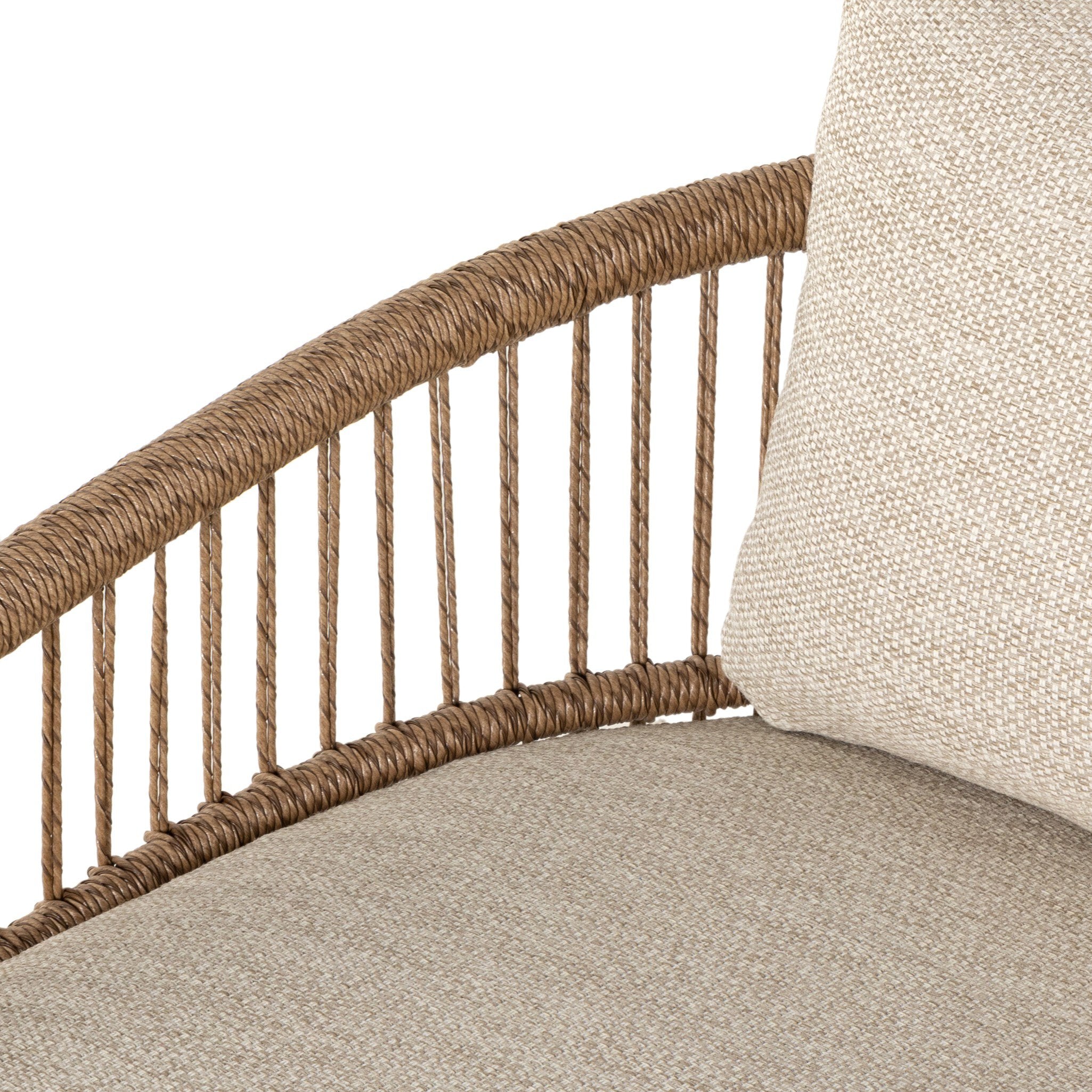 A close up of a cottage inspired outdoor chair with wrapping and texture along with beige colored upholstered cushions on a white background. 