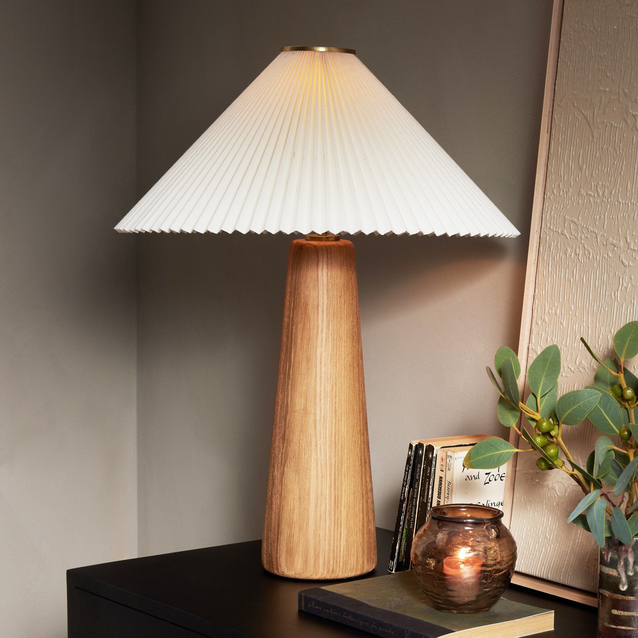 Wooden table lamp with pleated white shade on a dark surface. | Wildwood Home Co.
