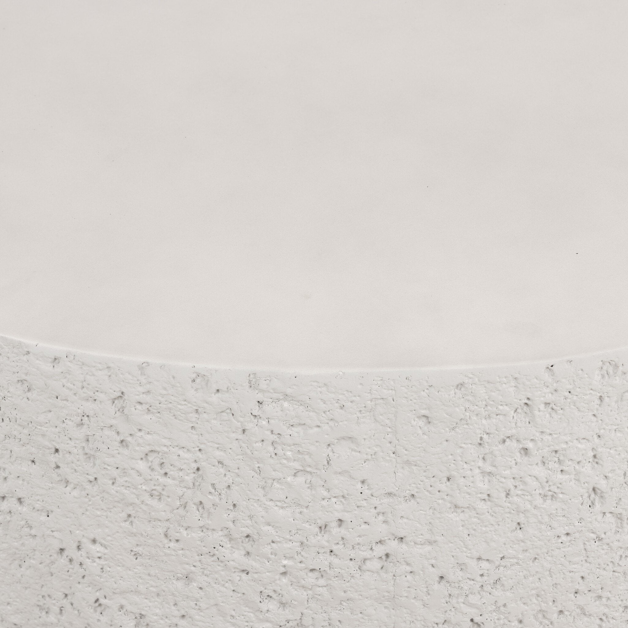 Close up of a concrete coffee table showing its textured edges and smooth top. 