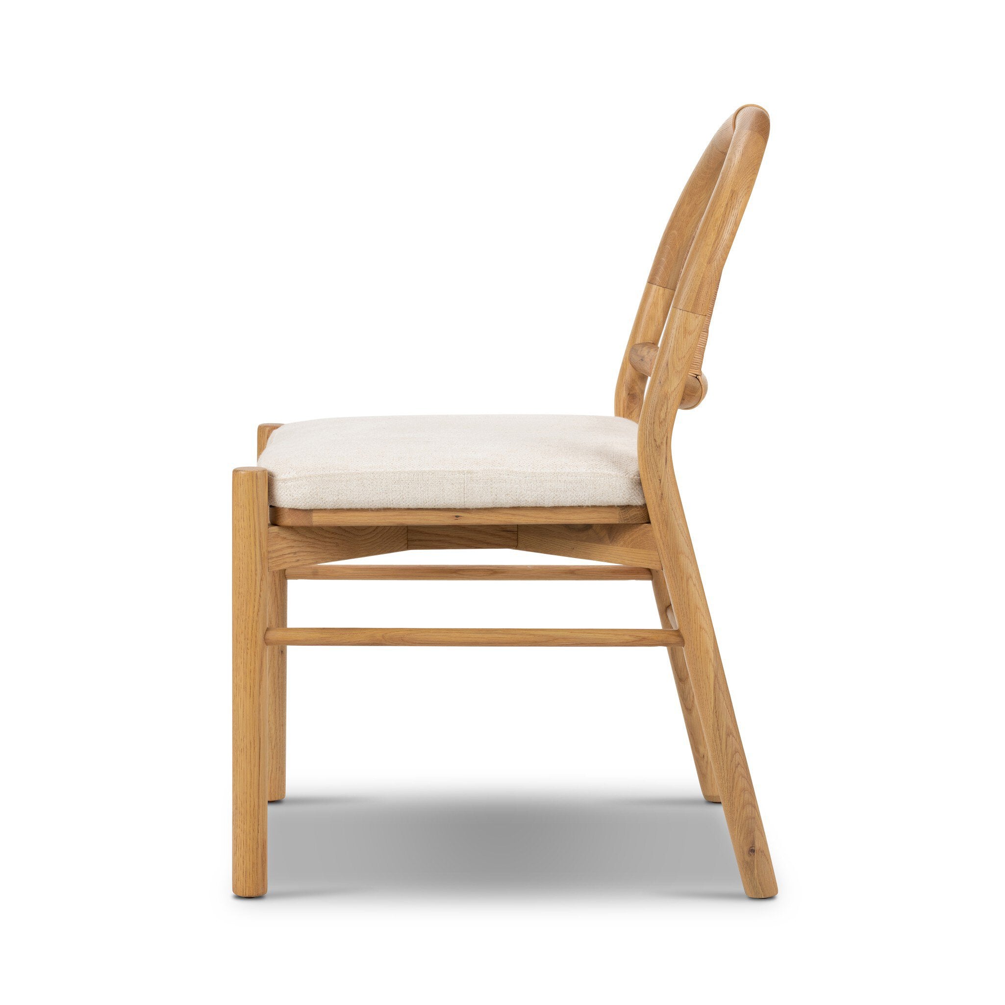 Side profile of a solid oak dining chair with an arched frame, hand-wrapped cane back detailing, and an upholstered drop-in seat. 