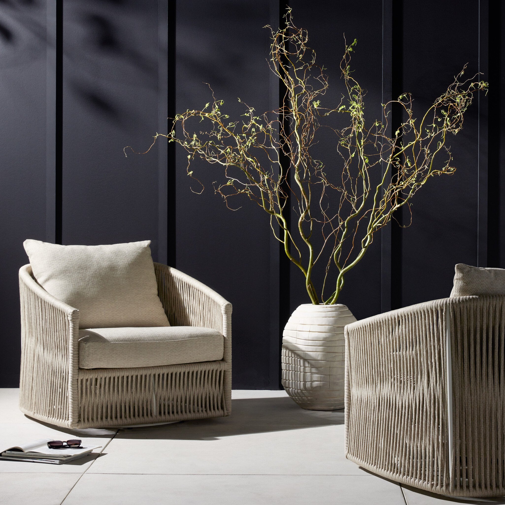 Two beige armchairs with a decorative plant against a dark wall. | Wildwood Home Co.