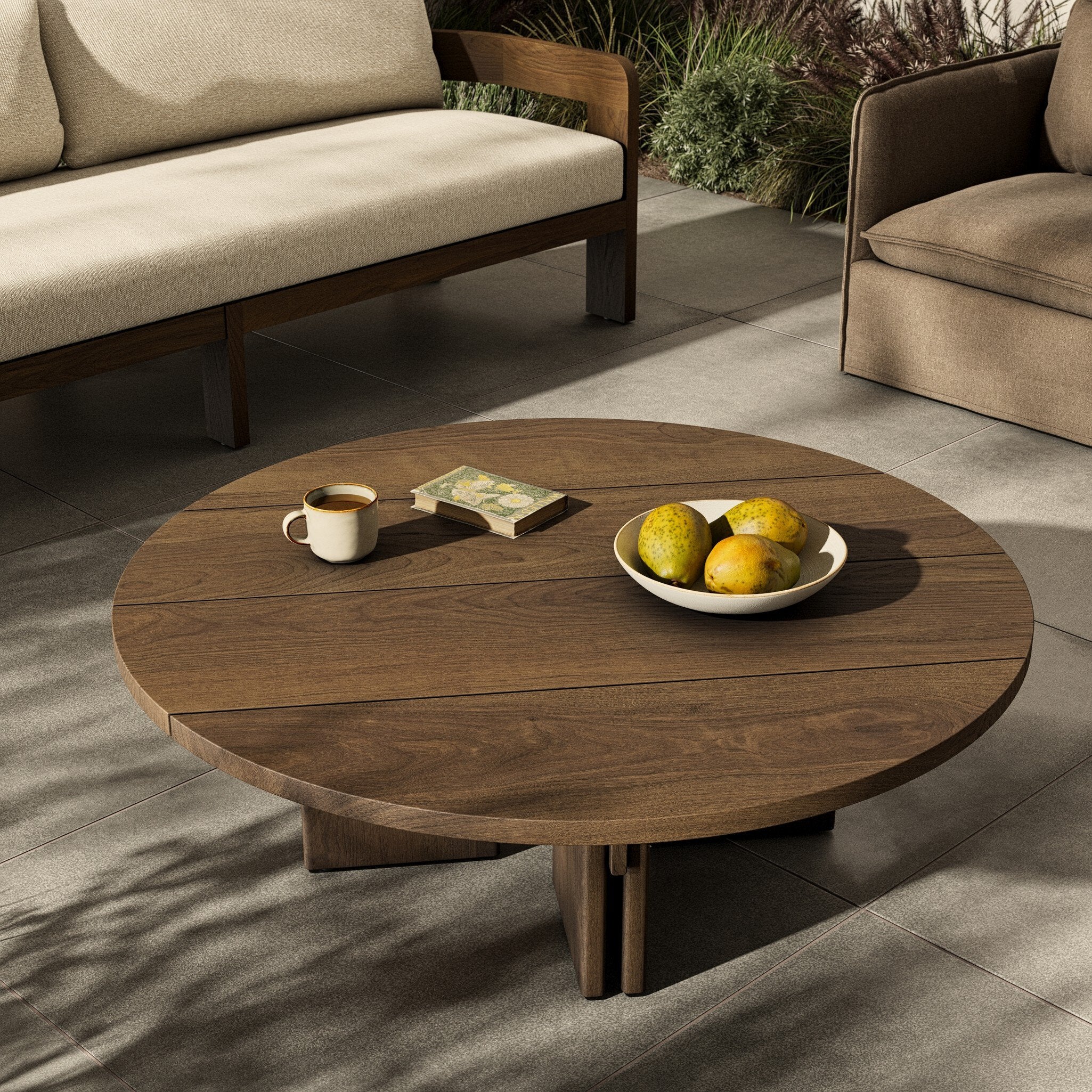 Round wooden coffee table with a cup and fruit on a patio setting. | Wildwood Home Co.
