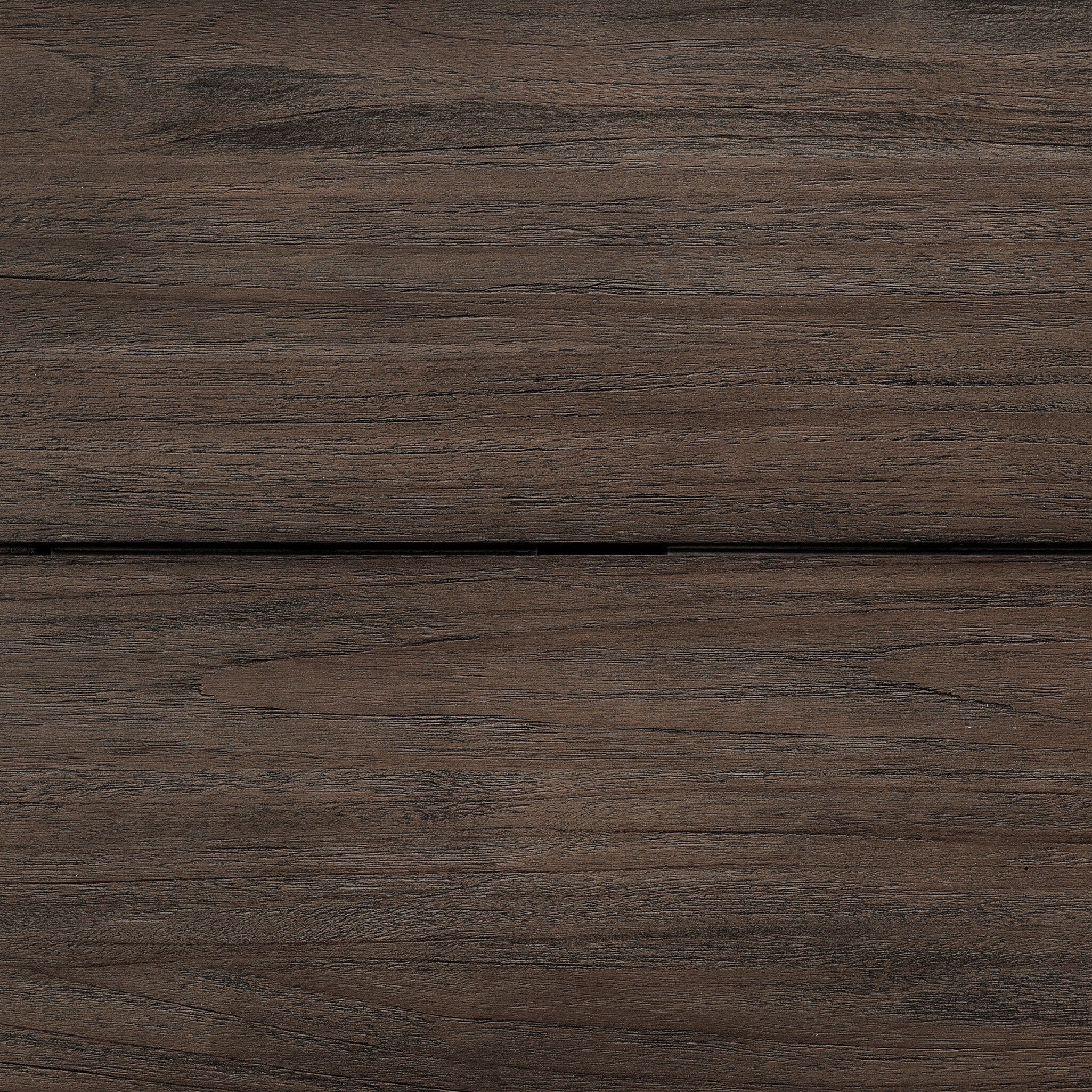 Close up on a solid teak dining table showing its dark brown finish and wood grain. 