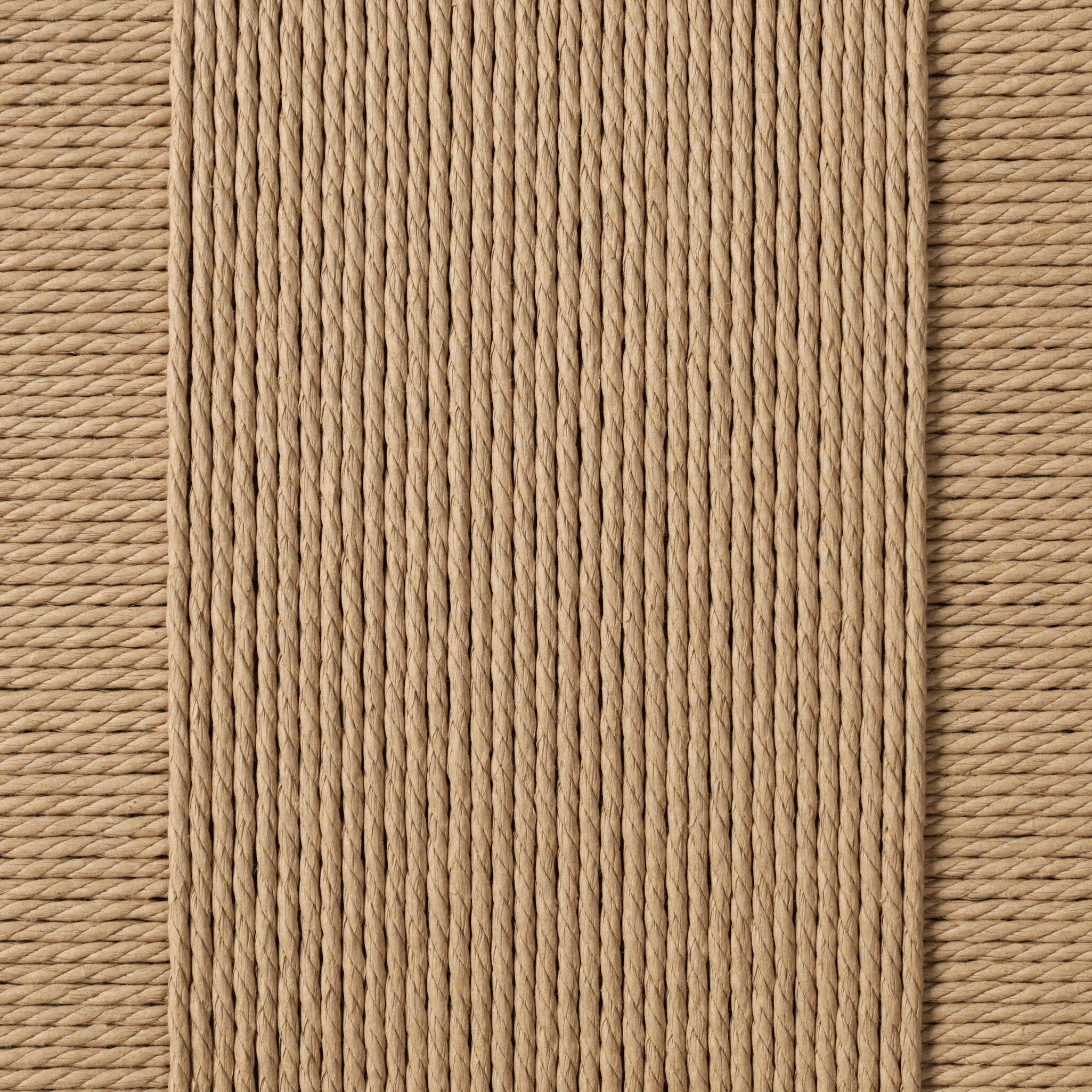 Close up of a dining chair with woven backrest and beige cushion on a white background.