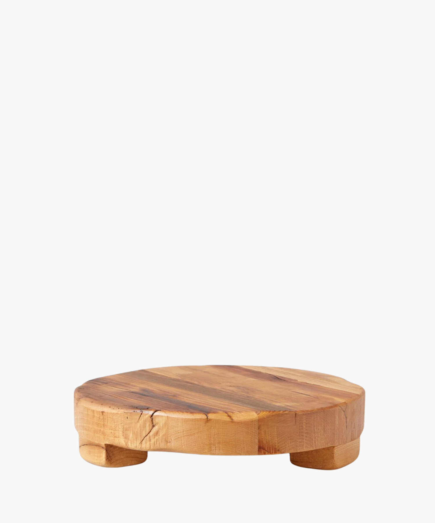 Round wooden pedestal or trivet made of smooth, natural wood with subtle grain patterns, supported by small rounded legs. Conveys rustic and minimalist elegance. | Wildwood Home Co.