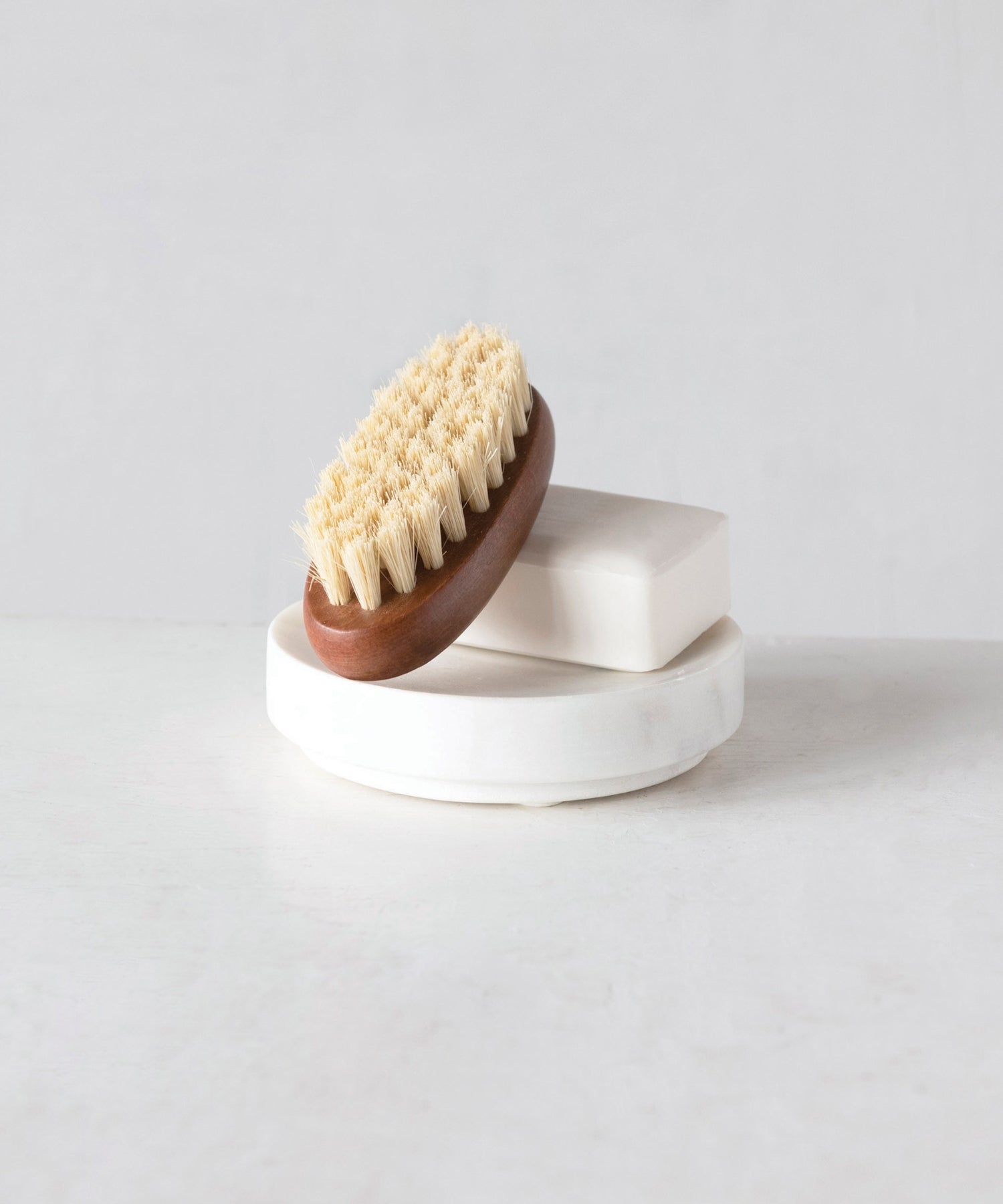 White round marble soap dish styled with soap ad brush. | Wildwood Home Co.