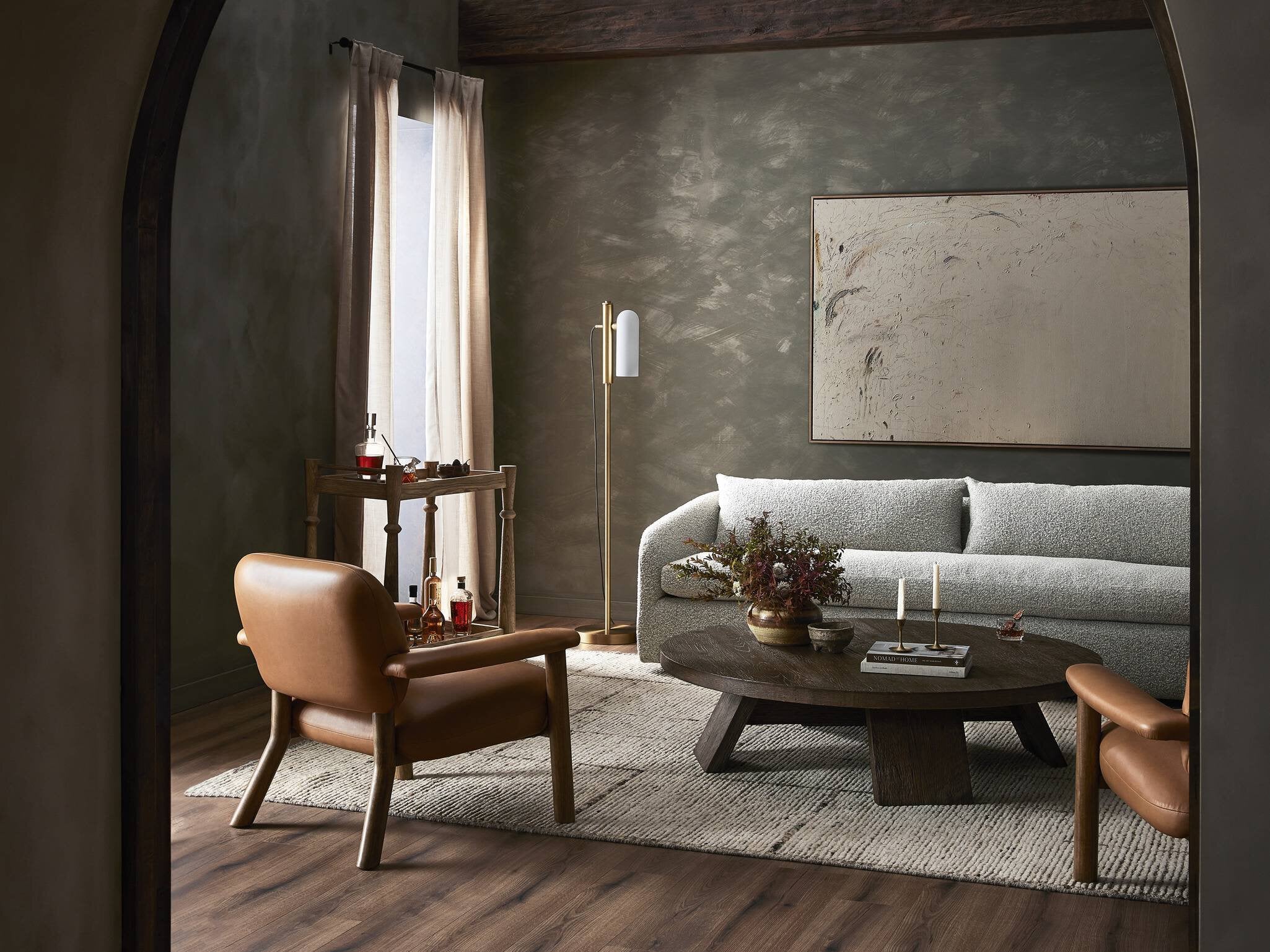 Modern living room with a gray sofa, wooden coffee table, and leather armchair. | Wildwood Home Co.