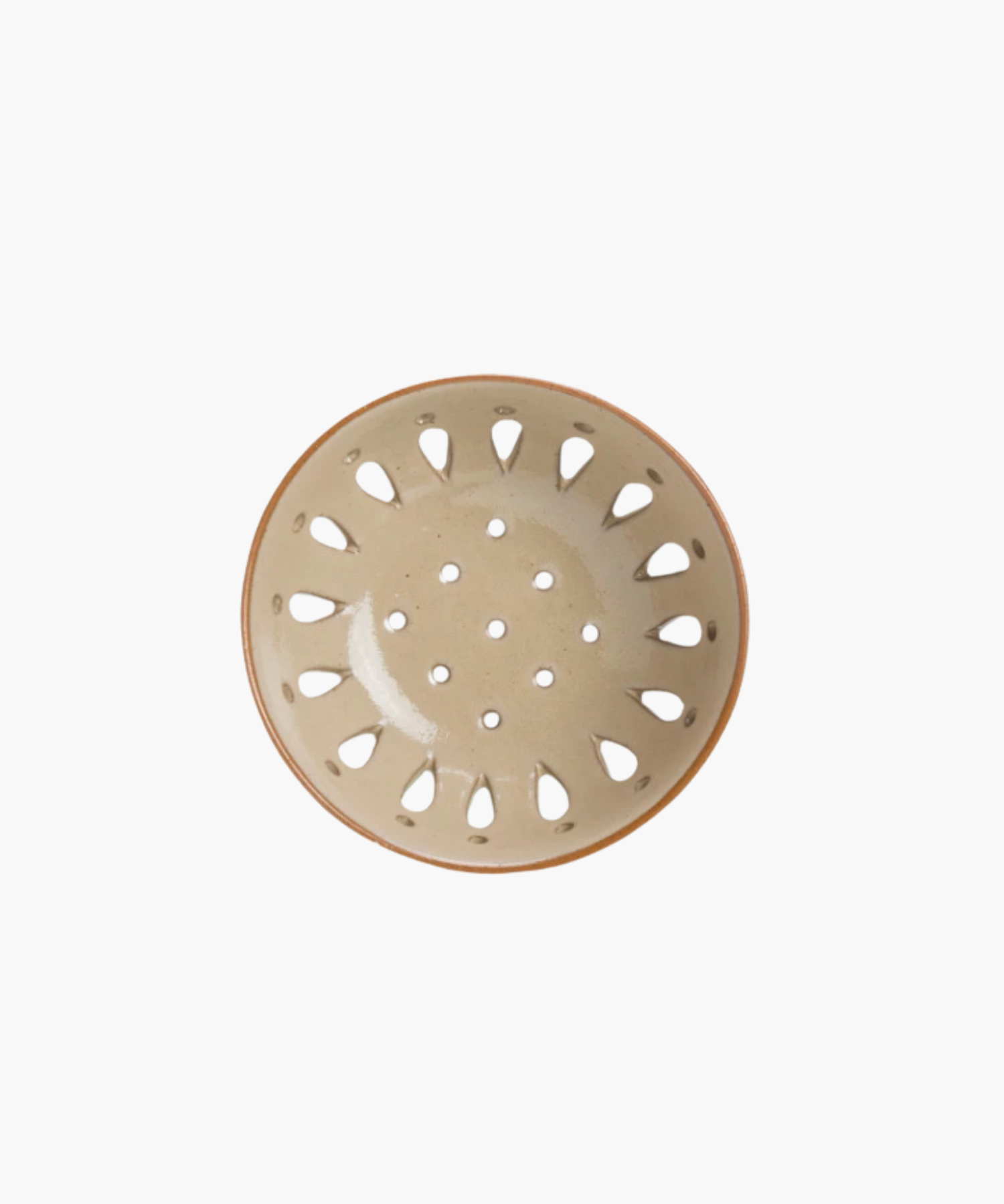 A beige ceramic colander with a light brown rim, featuring round holes and teardrop-shaped cutouts, standing out against a plain white background.
