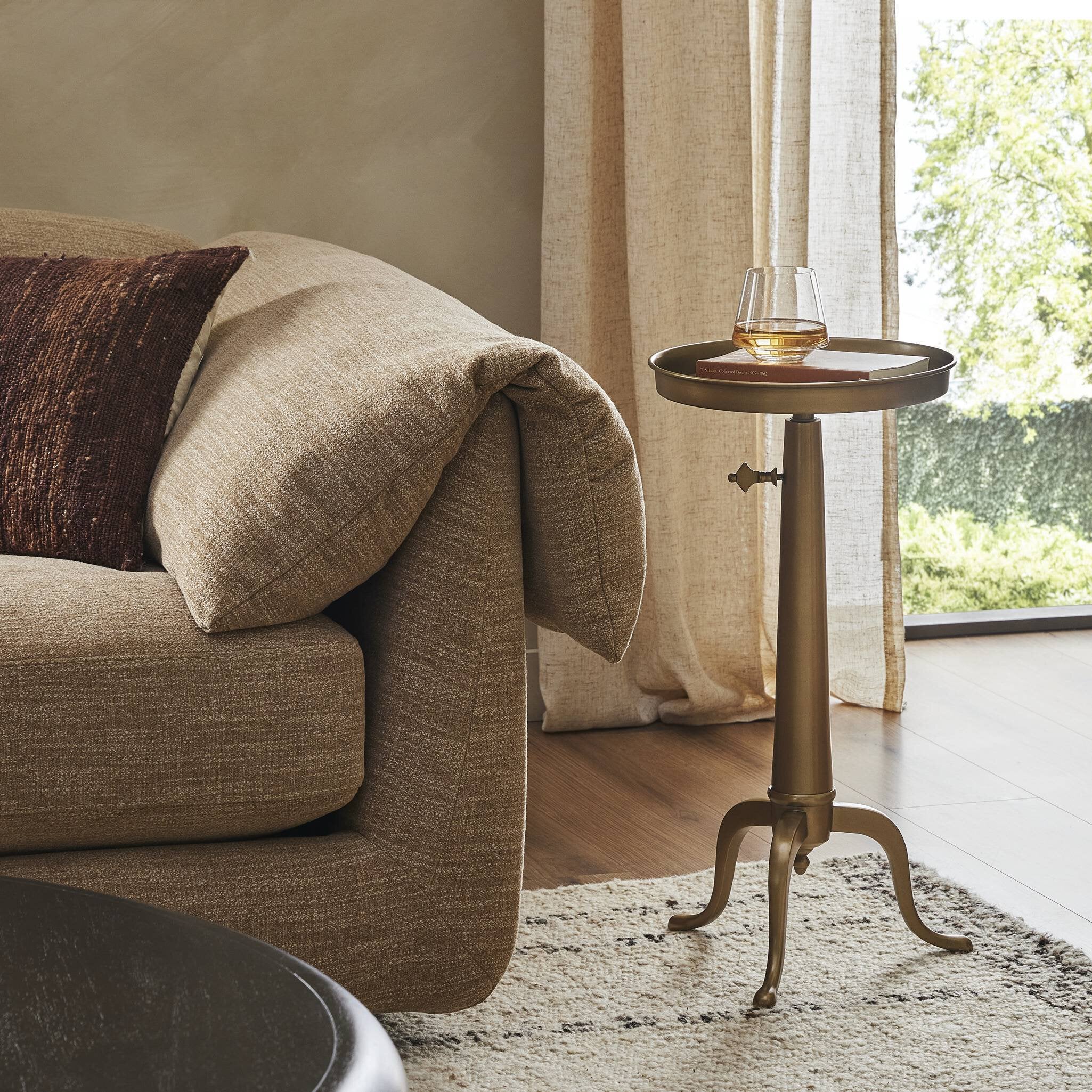 Beige sofa with a brass end table in a living room setting. | Wildwood Home Co.