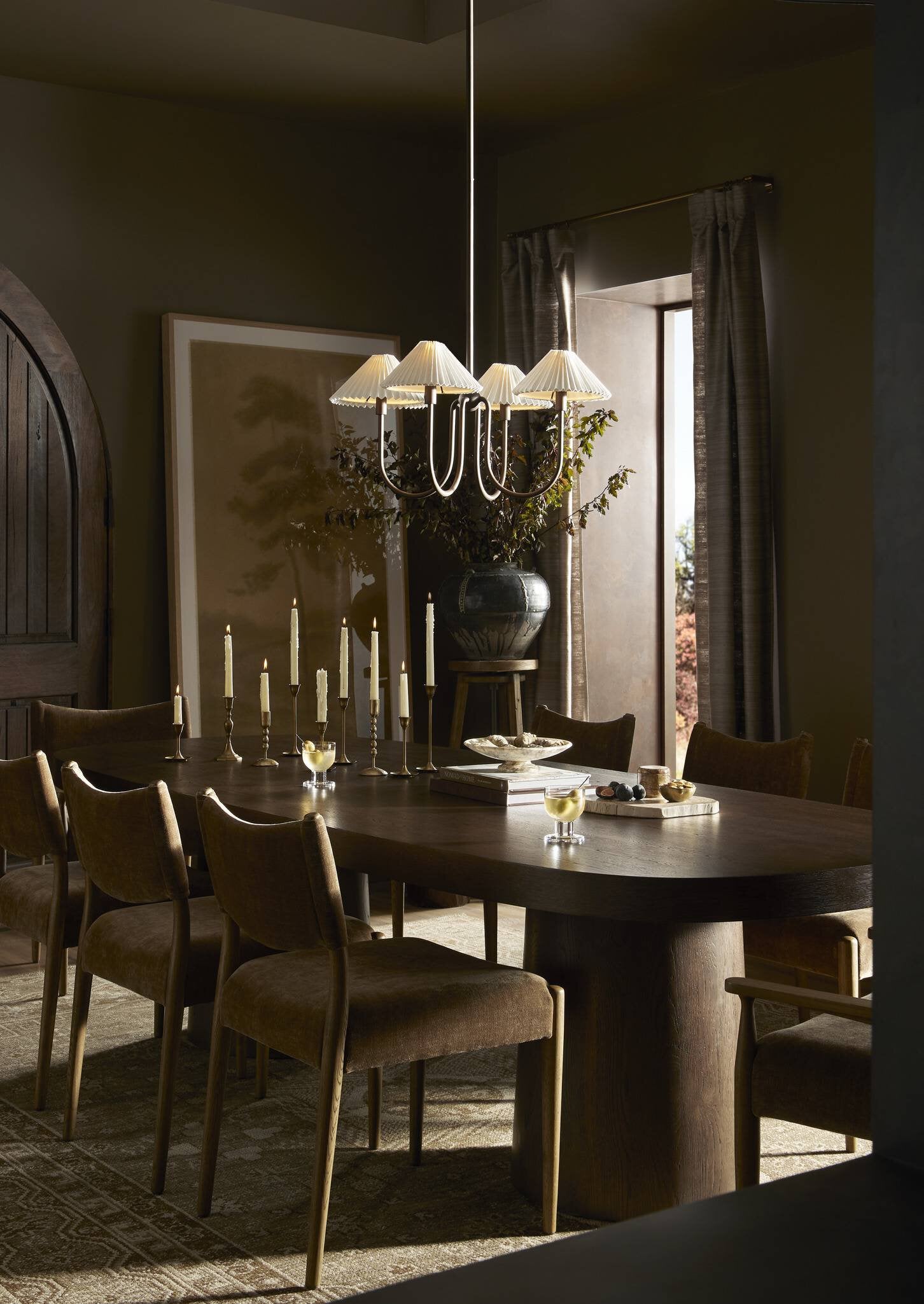 Dining room with a round table and chairs, featuring a chandelier.