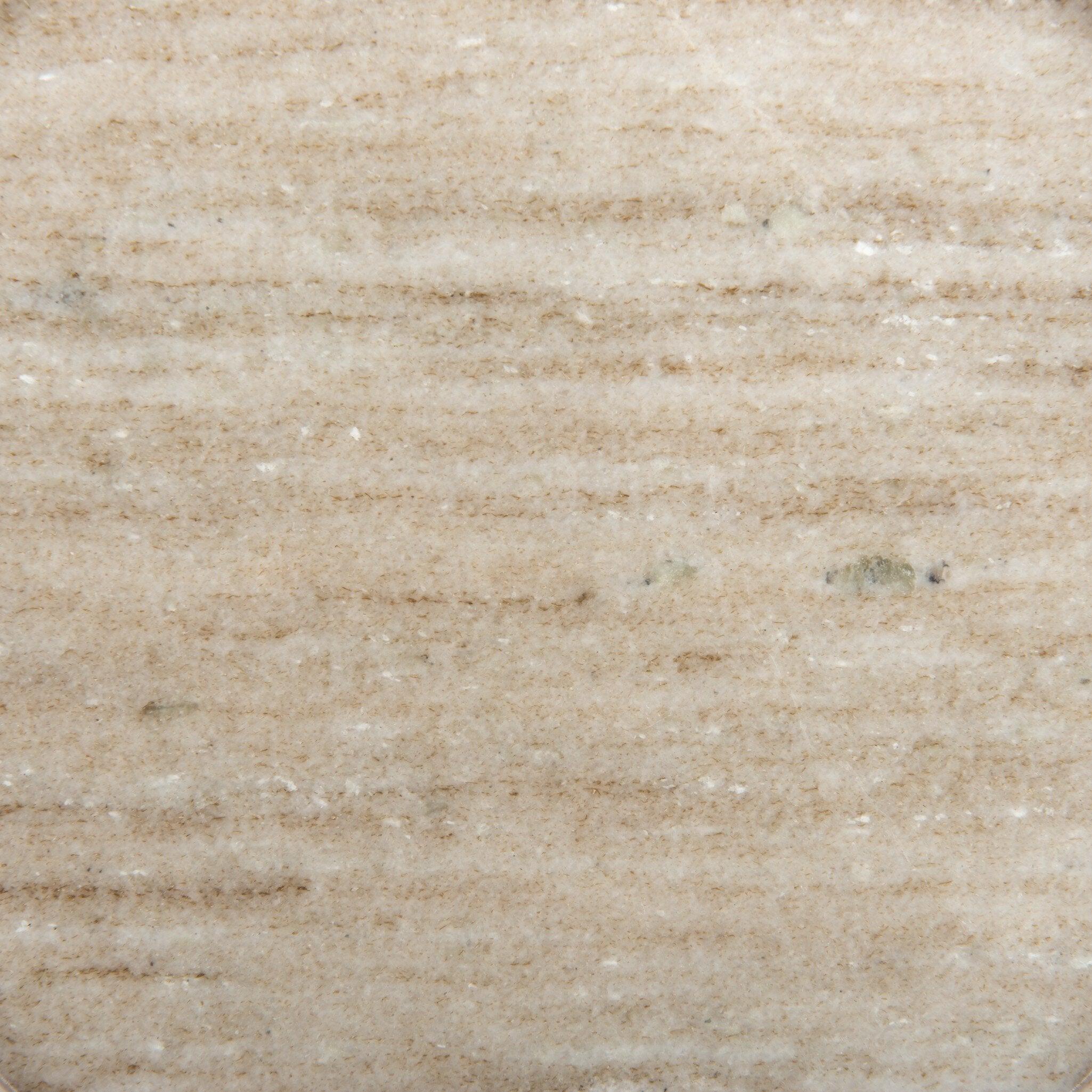 Close up view of the white antique marble showing its beige coloring and veining. 