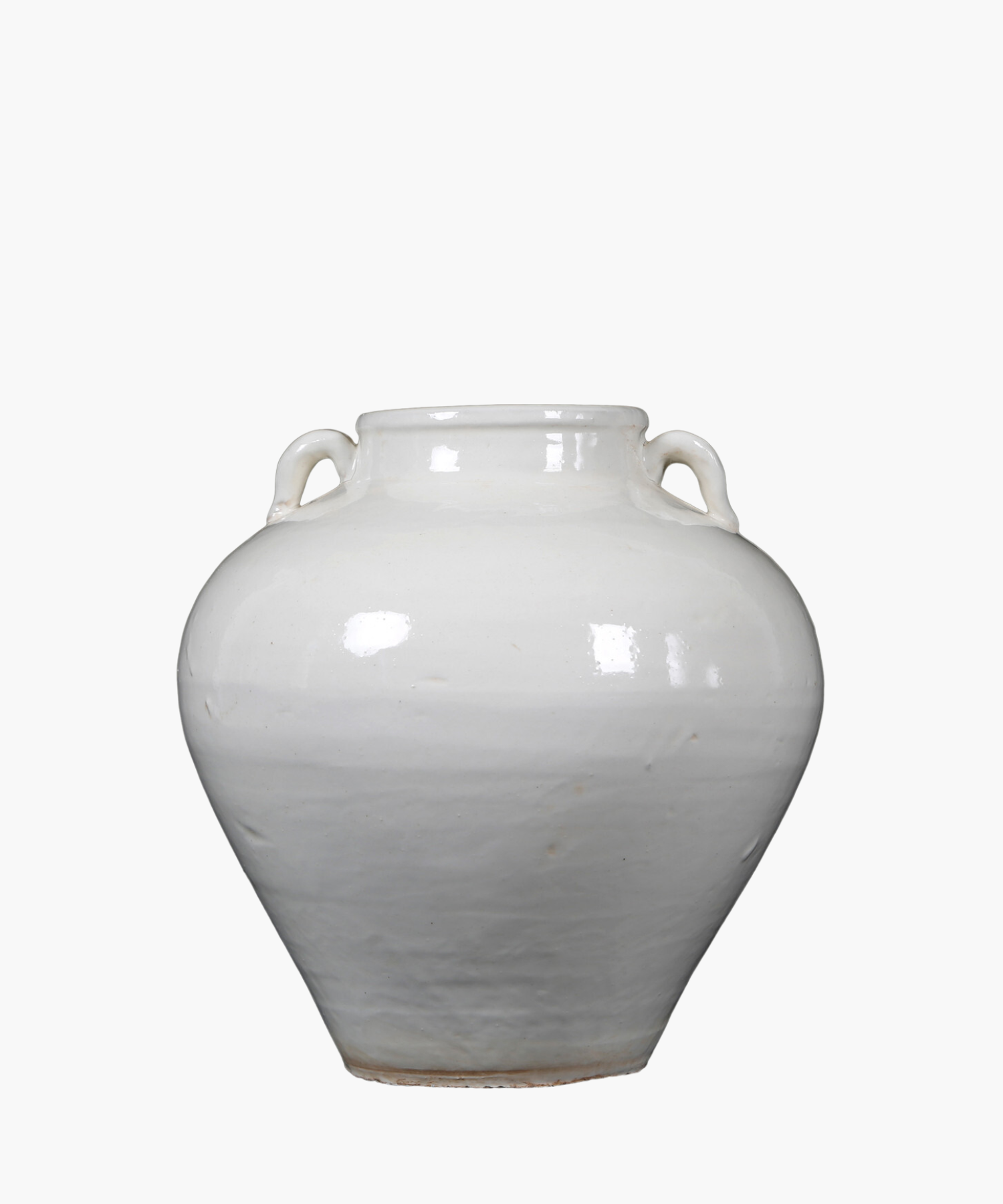 A simple, antique inspired white ceramic vase with two small handles near the neck, reflecting light softly, set against a plain white background. | Wildwood Home Co.