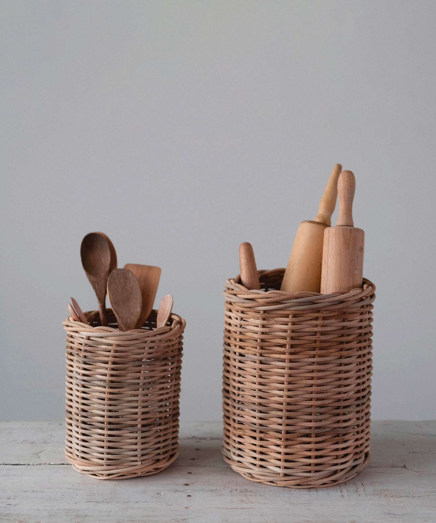 Hand woven wicker basket container in 2 sizes styled with wooden spoons and rolling pins. Both have a natural, woven texture, evoking a rustic, cozy feel. | Wildwood Home Co.