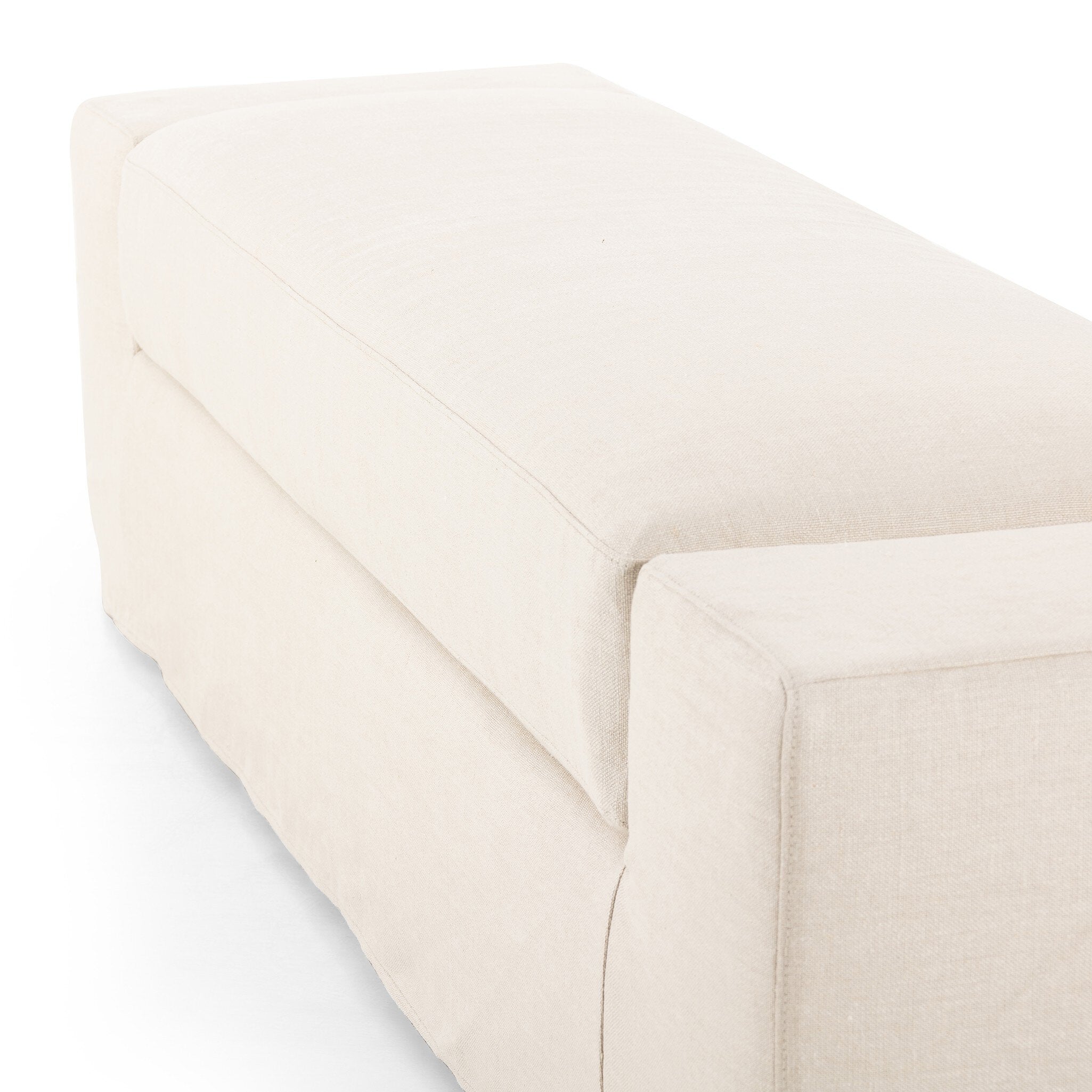 Ivory wide arm slipcover accent bench on a white background.