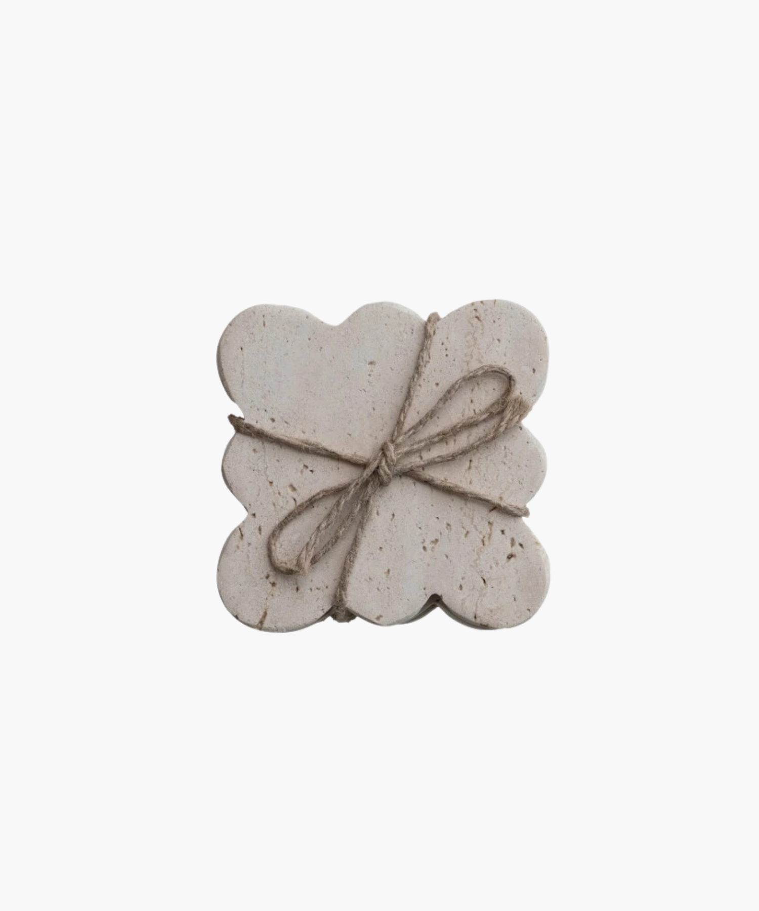 Travertine rectangular coasters with scalloped edges, wrapped in rustic twine tied in a bow. The coasters have a natural, textured appearance, evoking simplicity. | Wildwood Home Co.