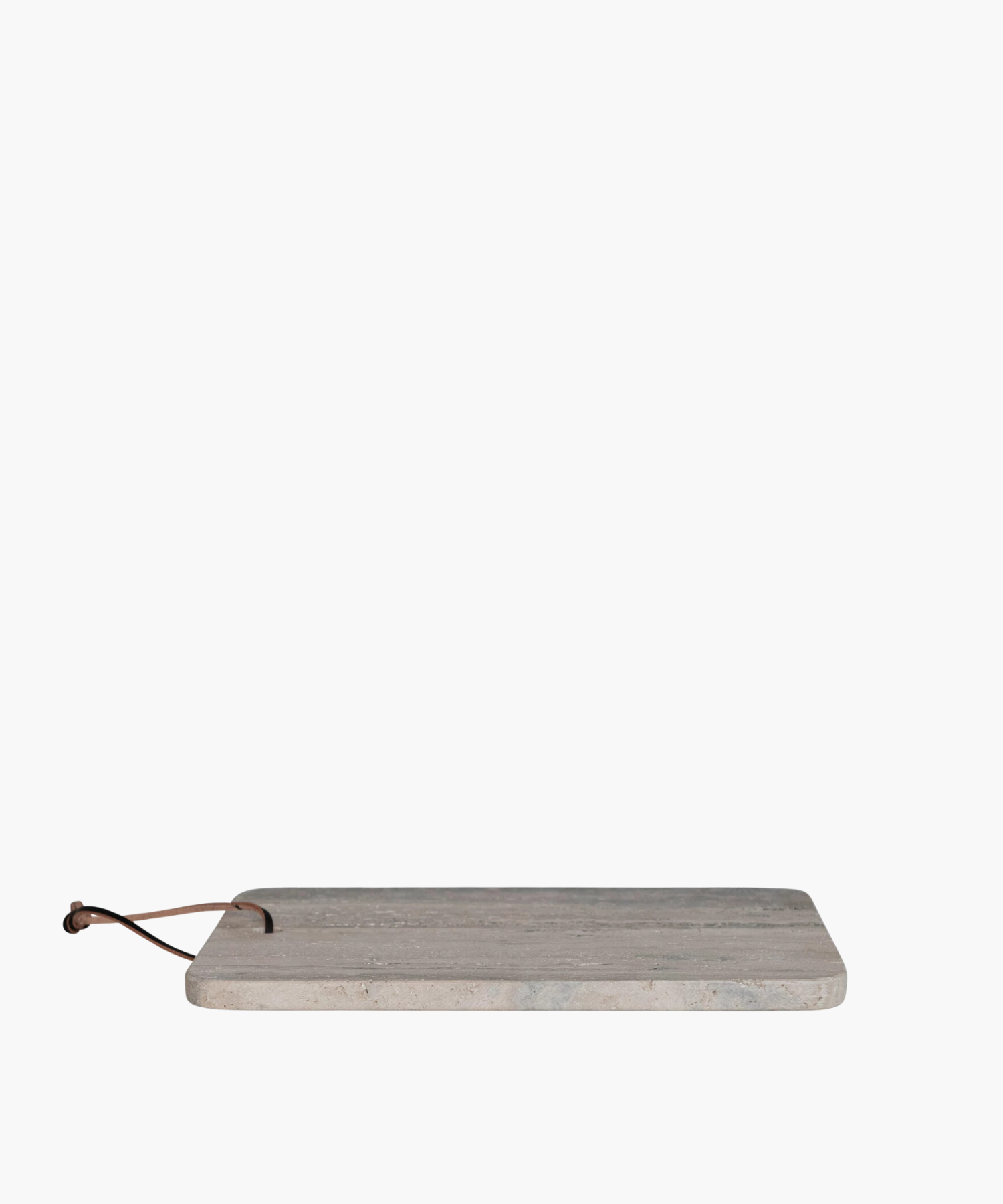 A side profile of a rectangular travertine cutting board with natural gray and beige veining, featuring rounded corners and a leather strap threaded through a hole at the top.