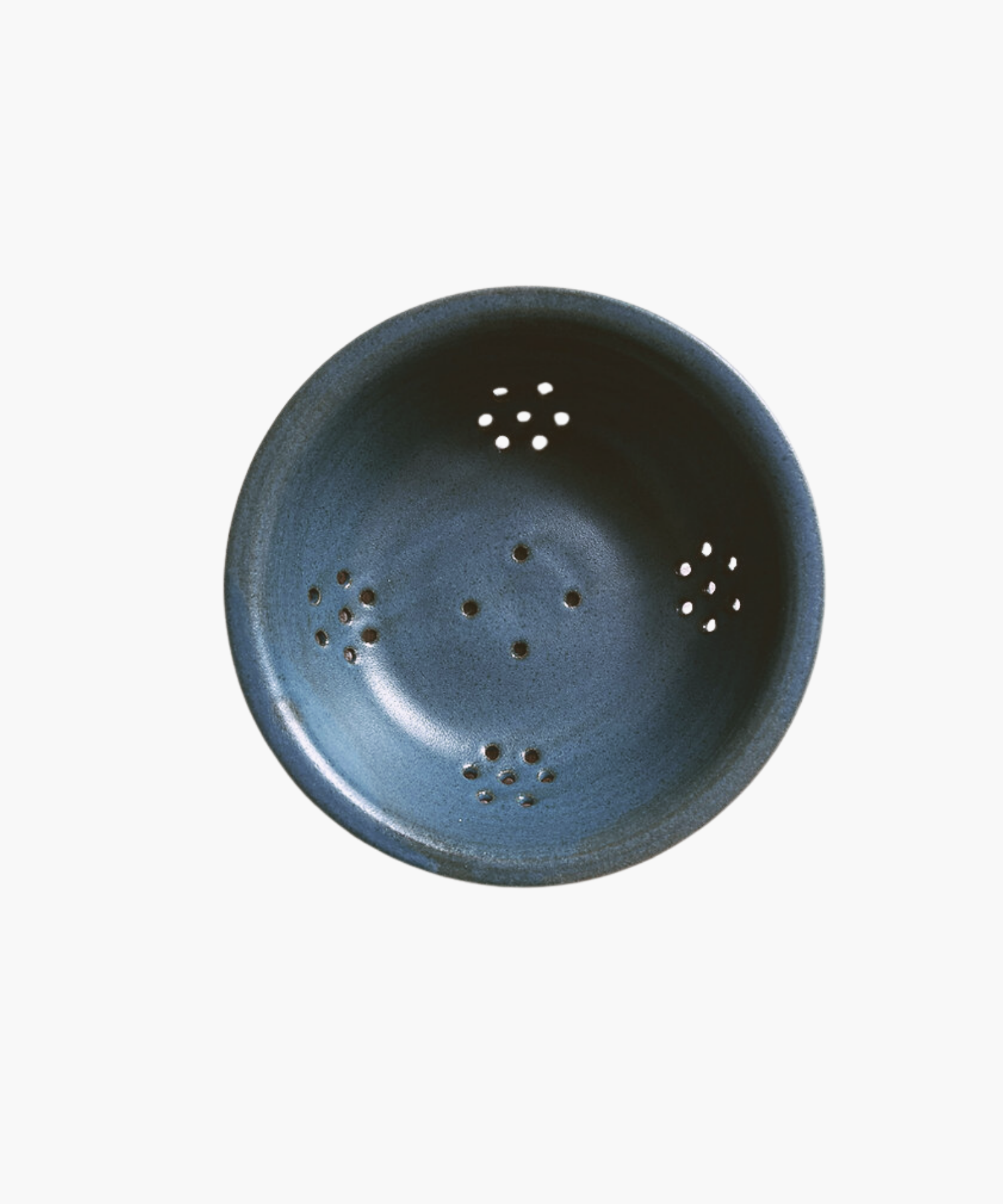 Blue ceramic colander with a smooth finish, featuring multiple small drainage holes arranged symmetrically. The tone is simple and functional. | Wildwood Home Co.