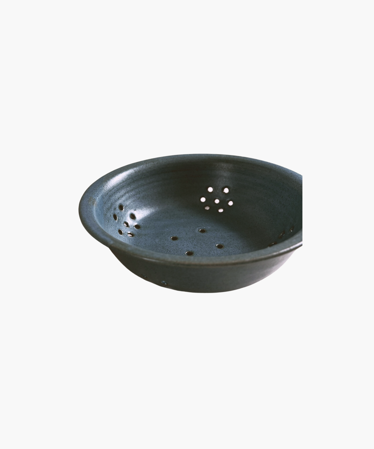 Blue ceramic colander with a smooth finish, featuring multiple small drainage holes arranged symmetrically. The tone is simple and functional. | Wildwood Home Co.